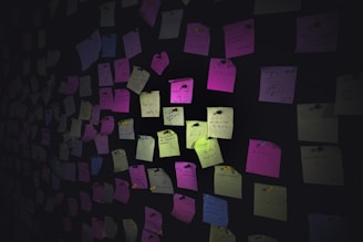 Colorful sticky notes cover a dark wall.