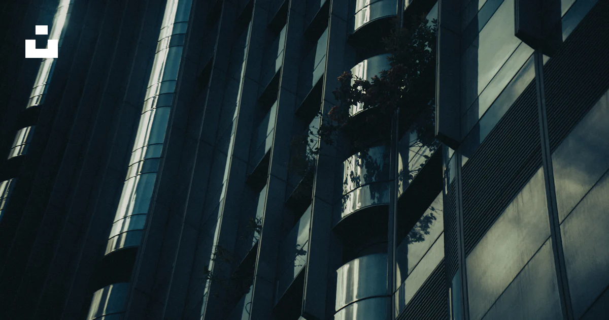 Here is a caption for the image: **tall modern building in dim lighting ...