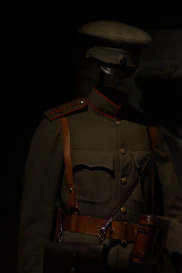 A military uniform displayed under dim lighting.