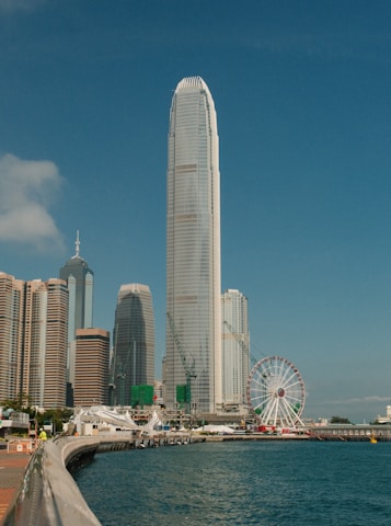 Hong kong skyline with a ferris wheel and skyscrapers.