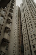 A tall, grungy apartment building reaches upward.