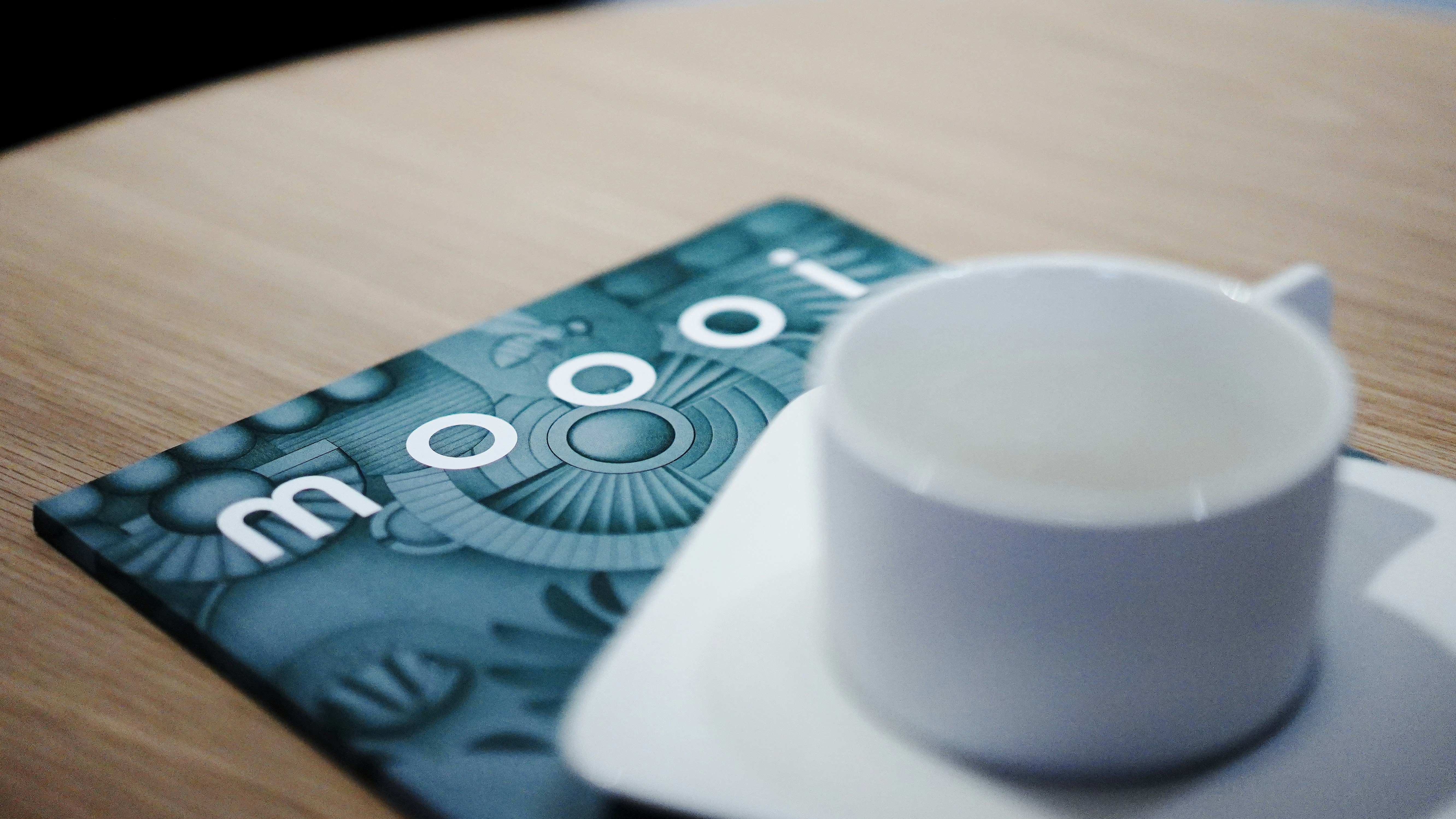 Empty cup on a saucer with a coaster.