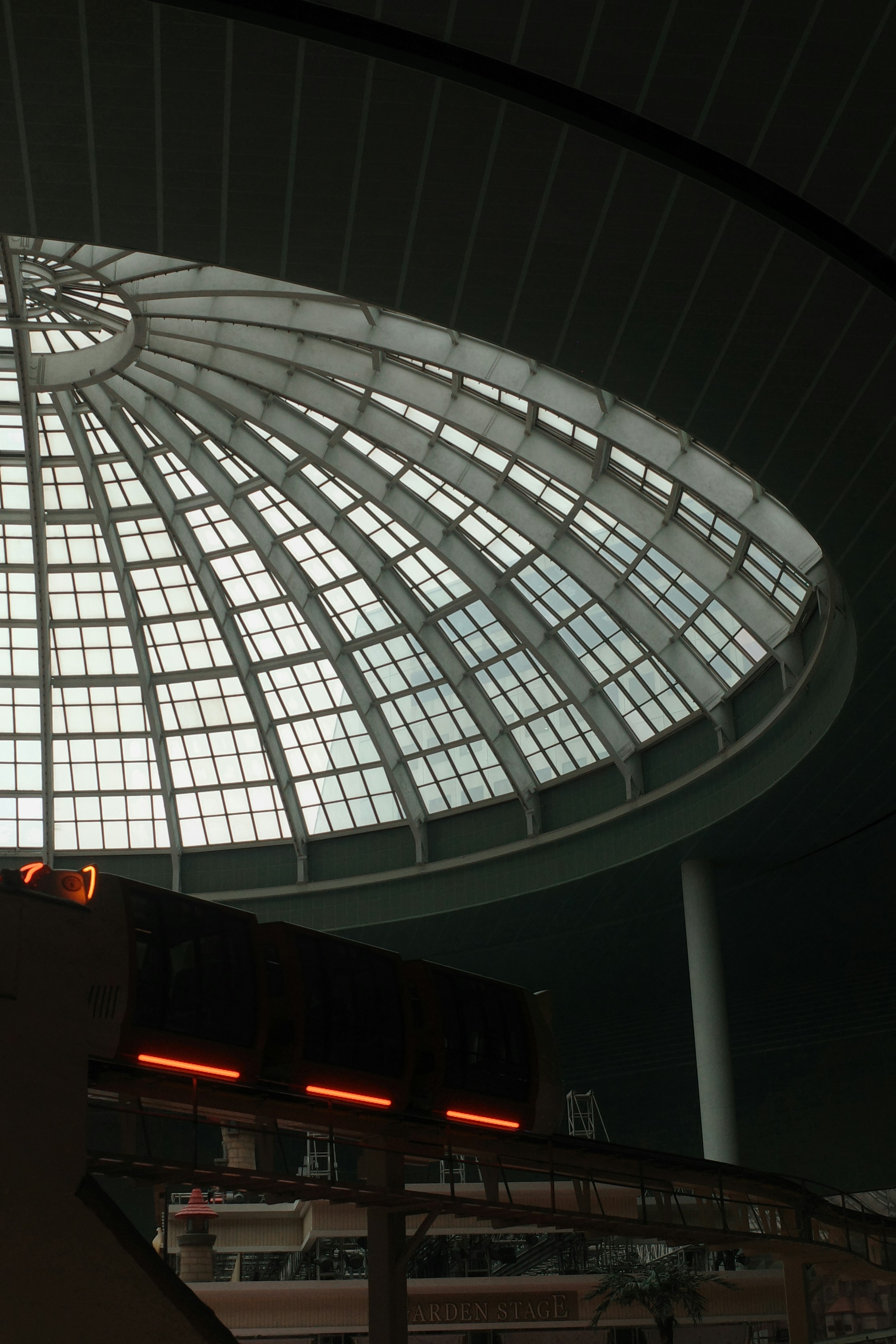 Ein großes Kuppelfenster blickt auf einen Zug herab.