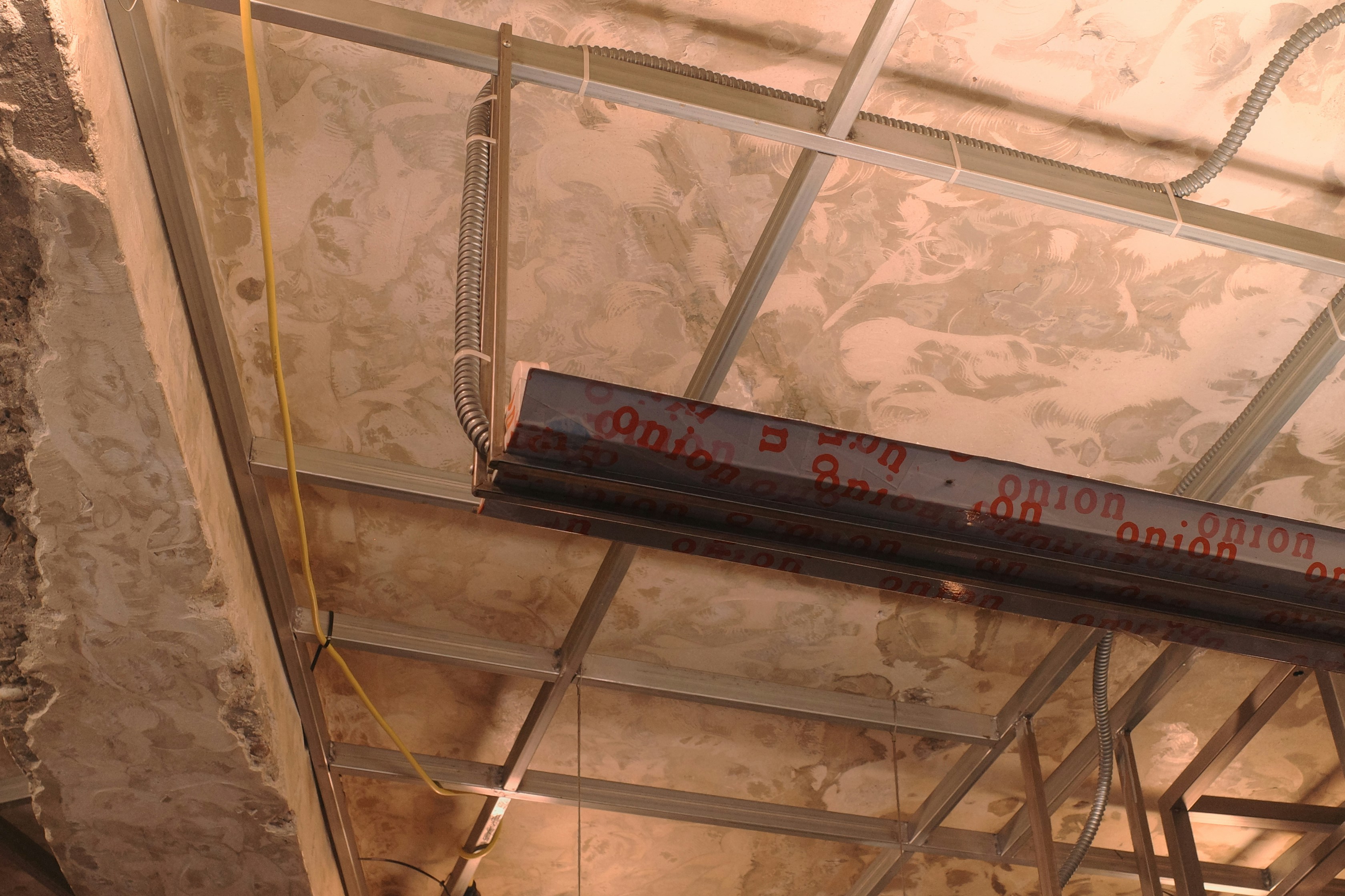 contractor measuring ceiling damage - ceiling leak repair cost