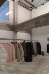 Clothing hangs on a rack in a minimalist boutique.