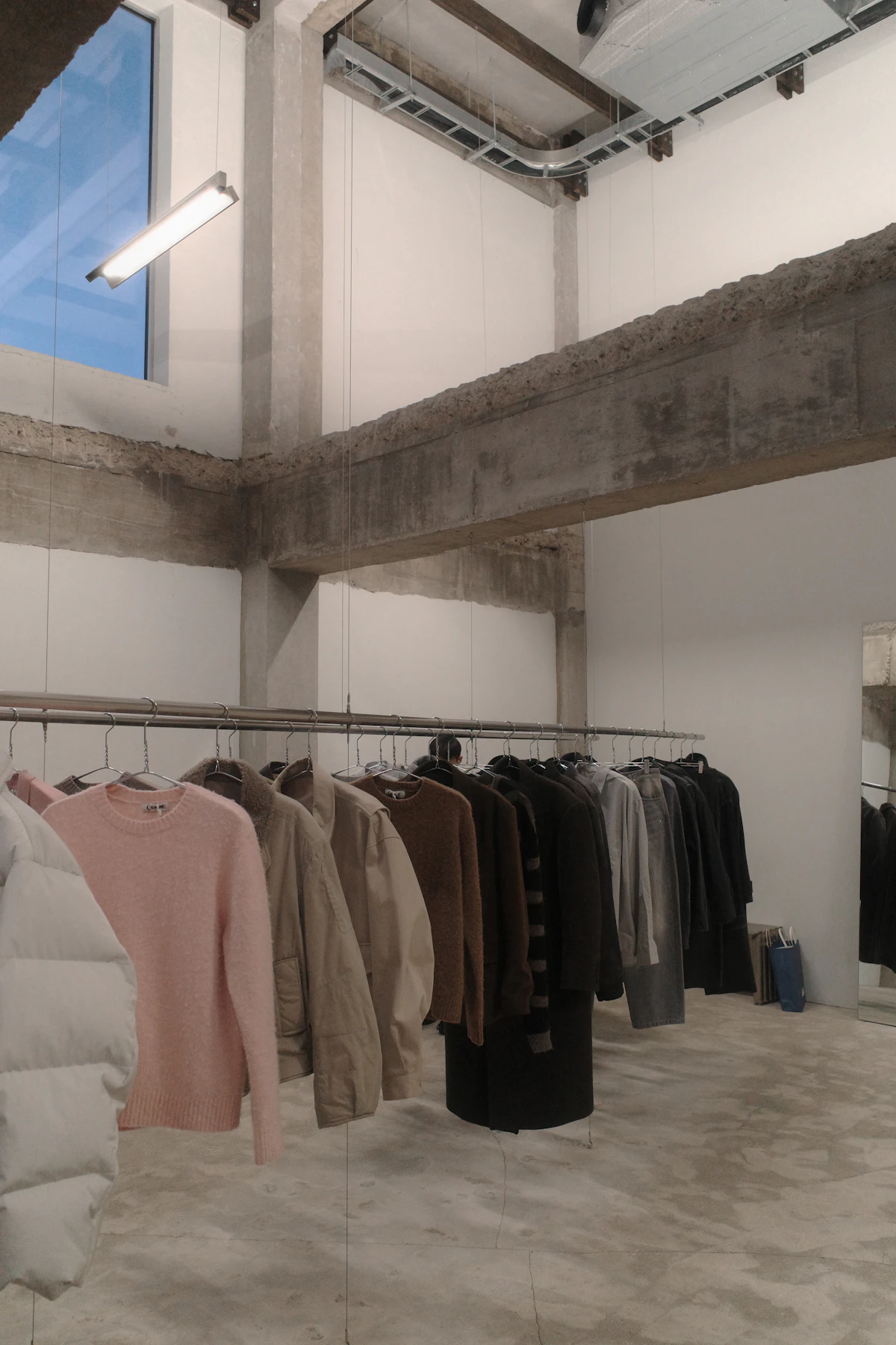 Intérieur épuré de la boutique Vintage Store, portants de pièces sélectionnées