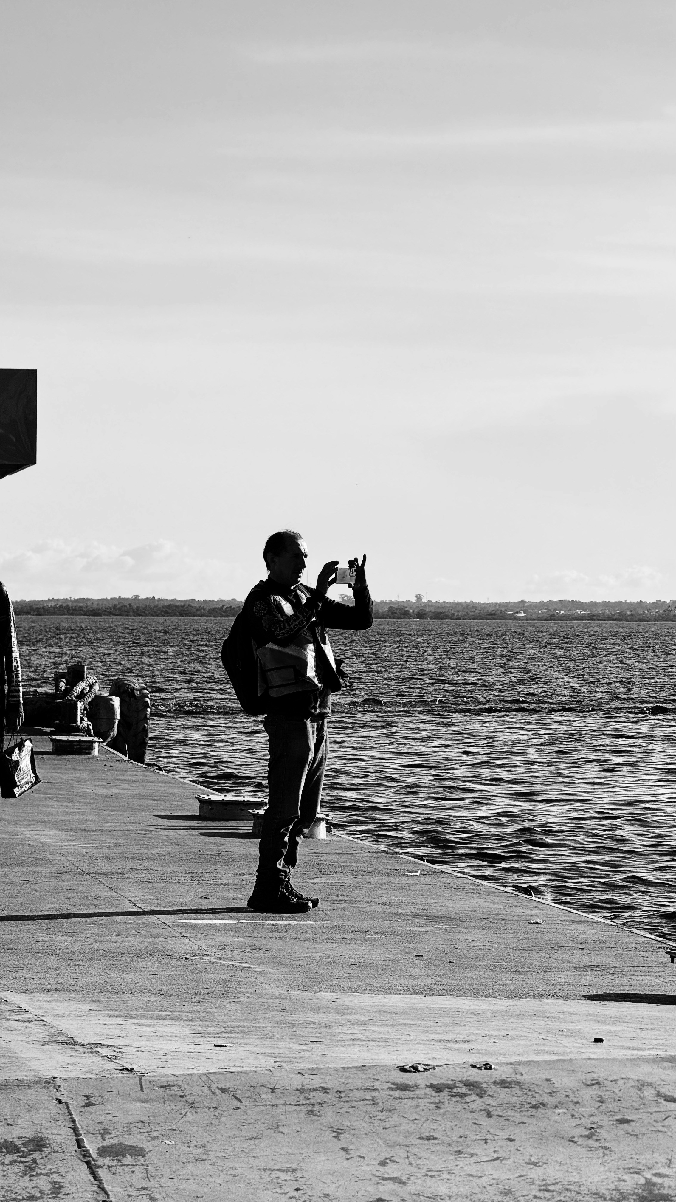 Um homem tira uma foto em um píer.