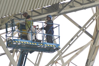 Workers use a lift to work on a building.