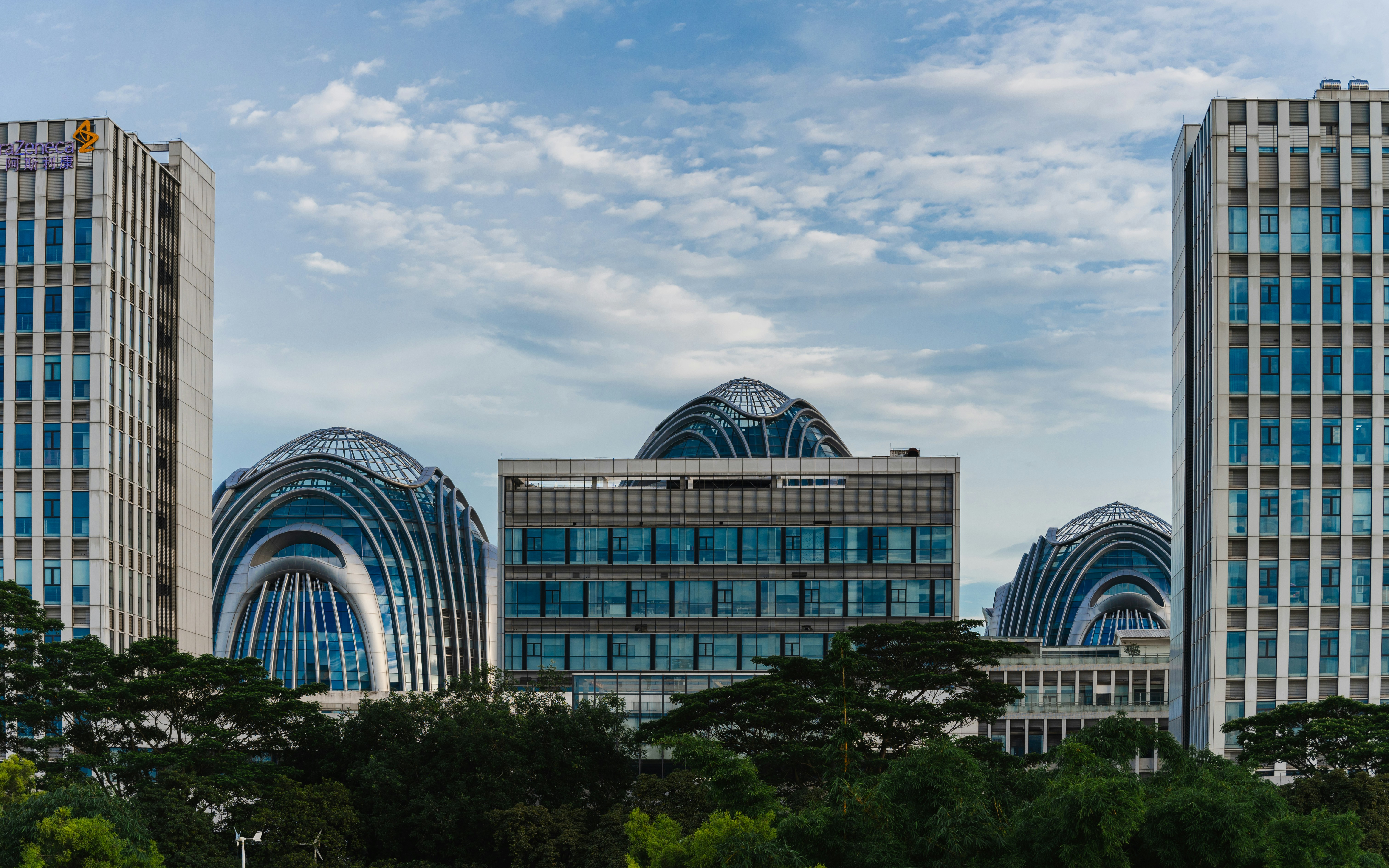 Modern buildings stand tall beneath a cloudy sky.