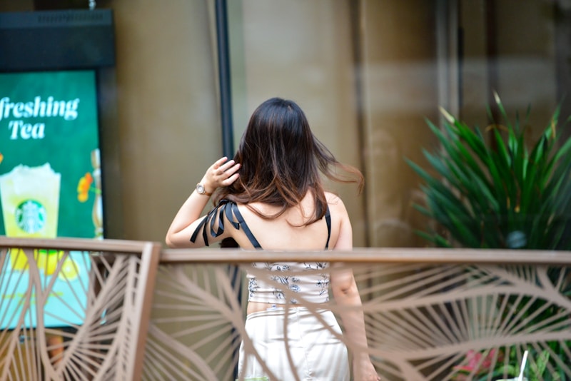 Woman walks past a starbucks, seen from the back.
