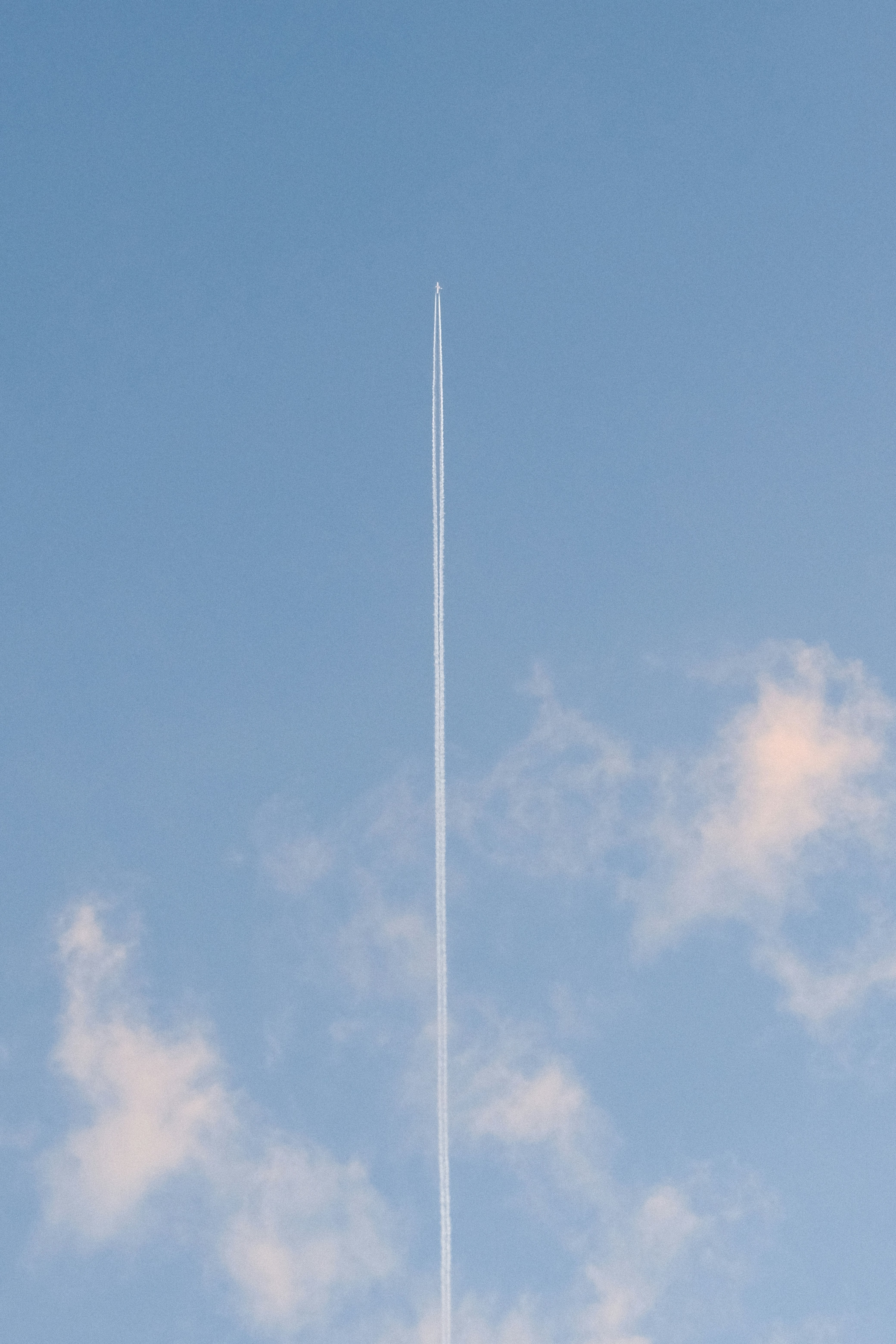 A plane leaves a vapor trail in the sky.