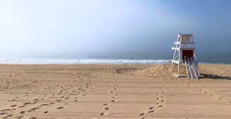 A lifeguard stand sits empty on the beach.