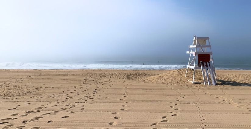 A lifeguard stand sits empty on the beach.