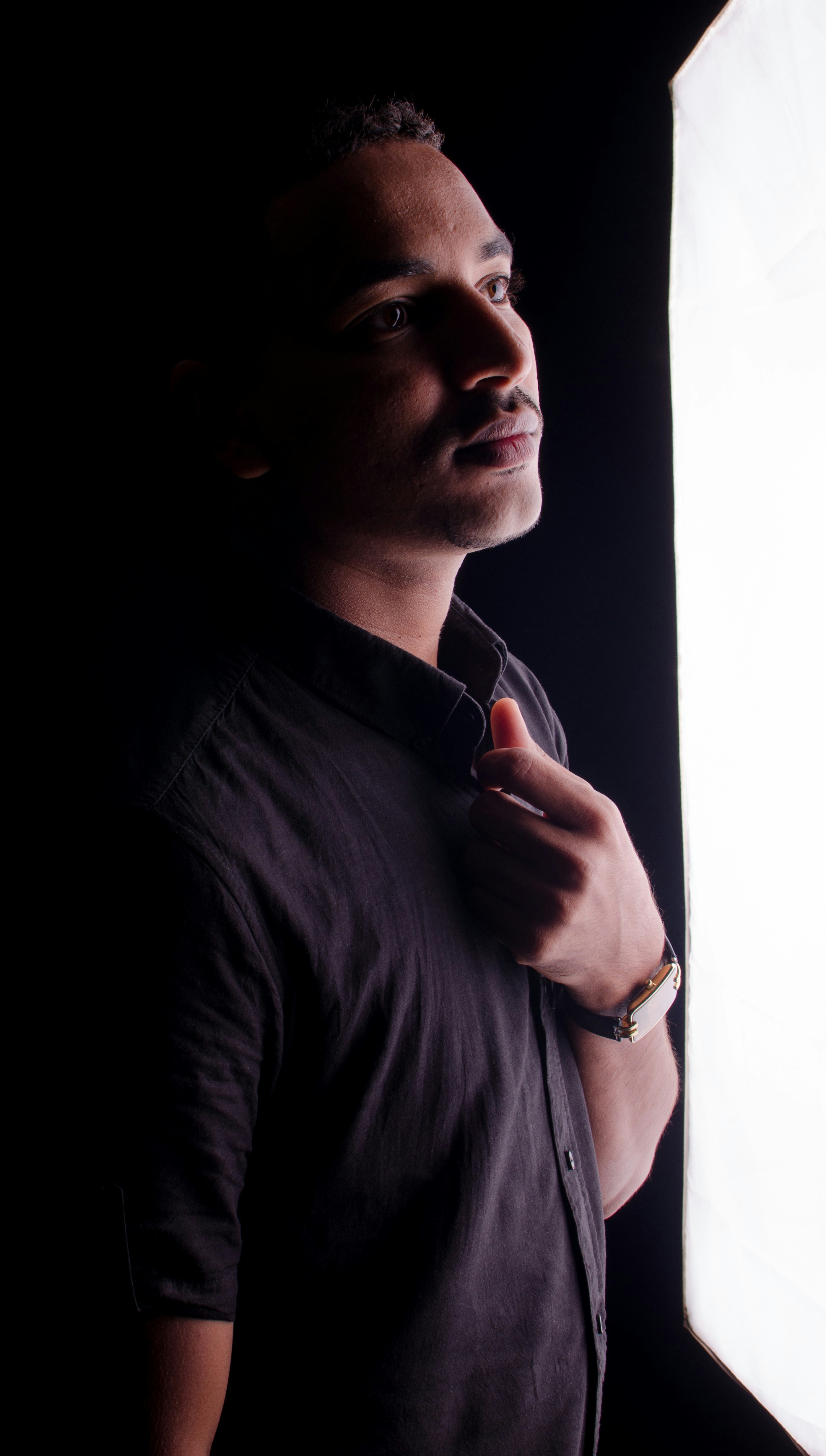 Man in the dark, illuminated by a bright light.