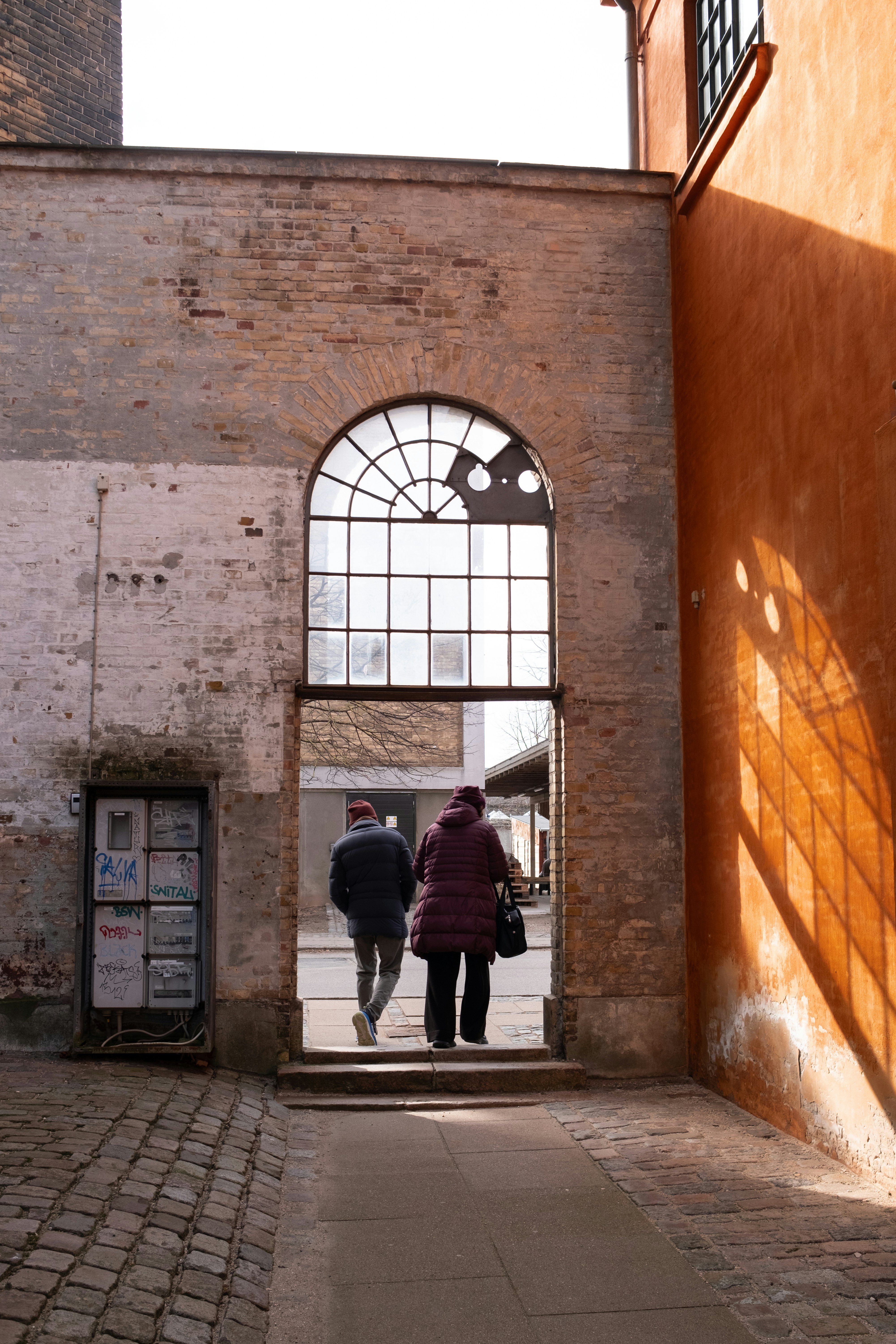 Two people walk through a doorway.