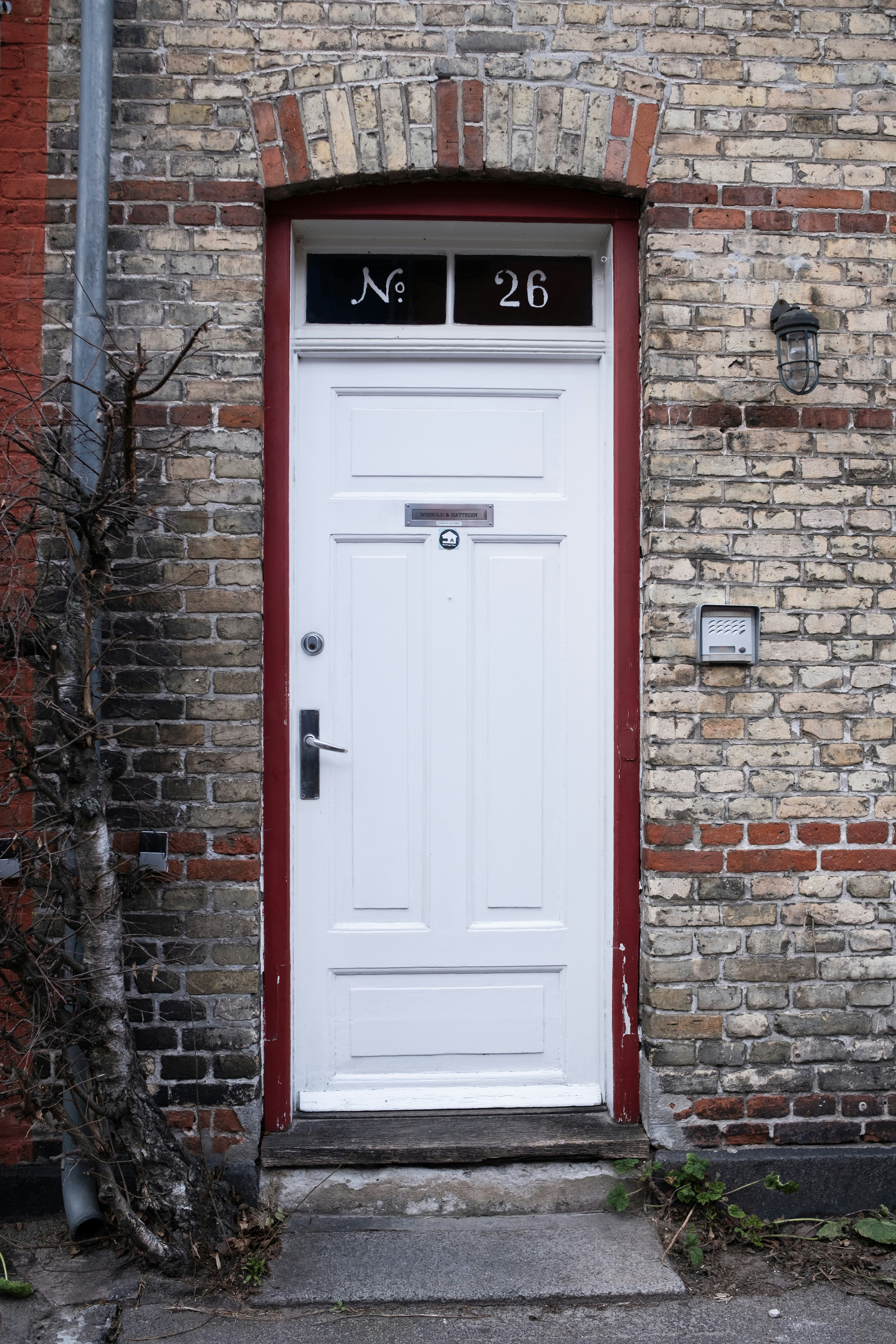 A white door on a brick building.