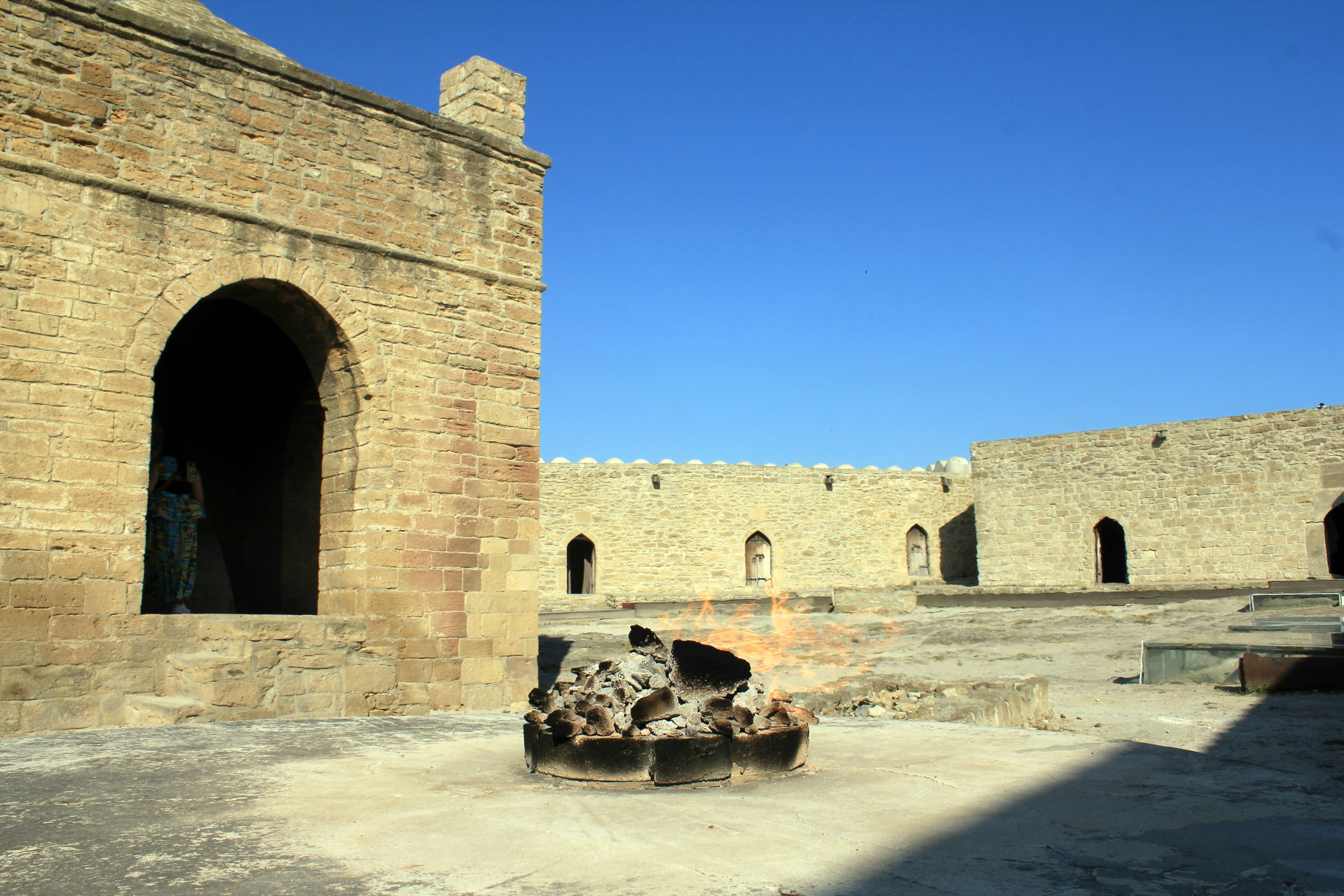 An ancient stone building with an eternal flame.