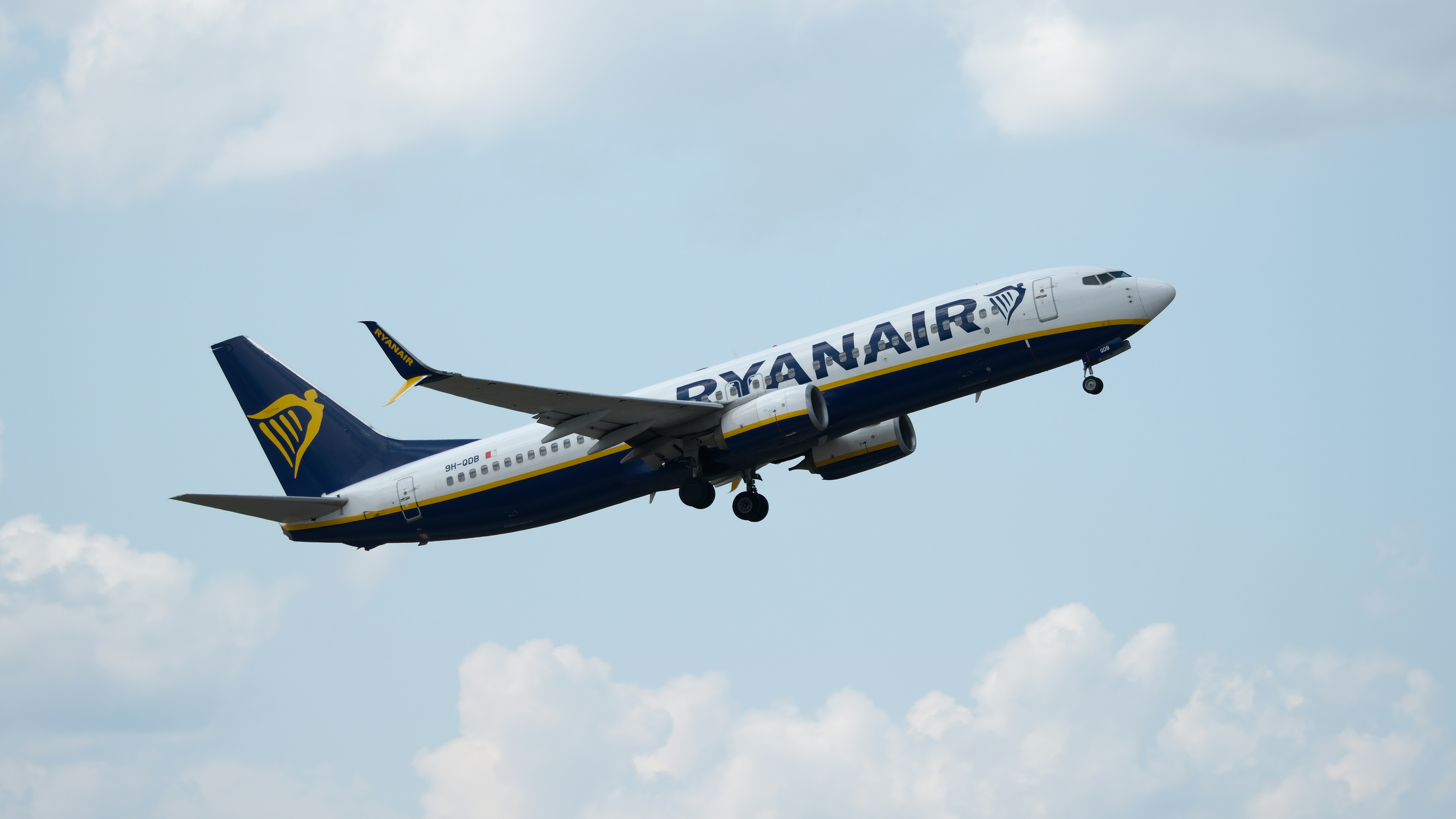 Un avión de Ryanair despega hacia el cielo azul.