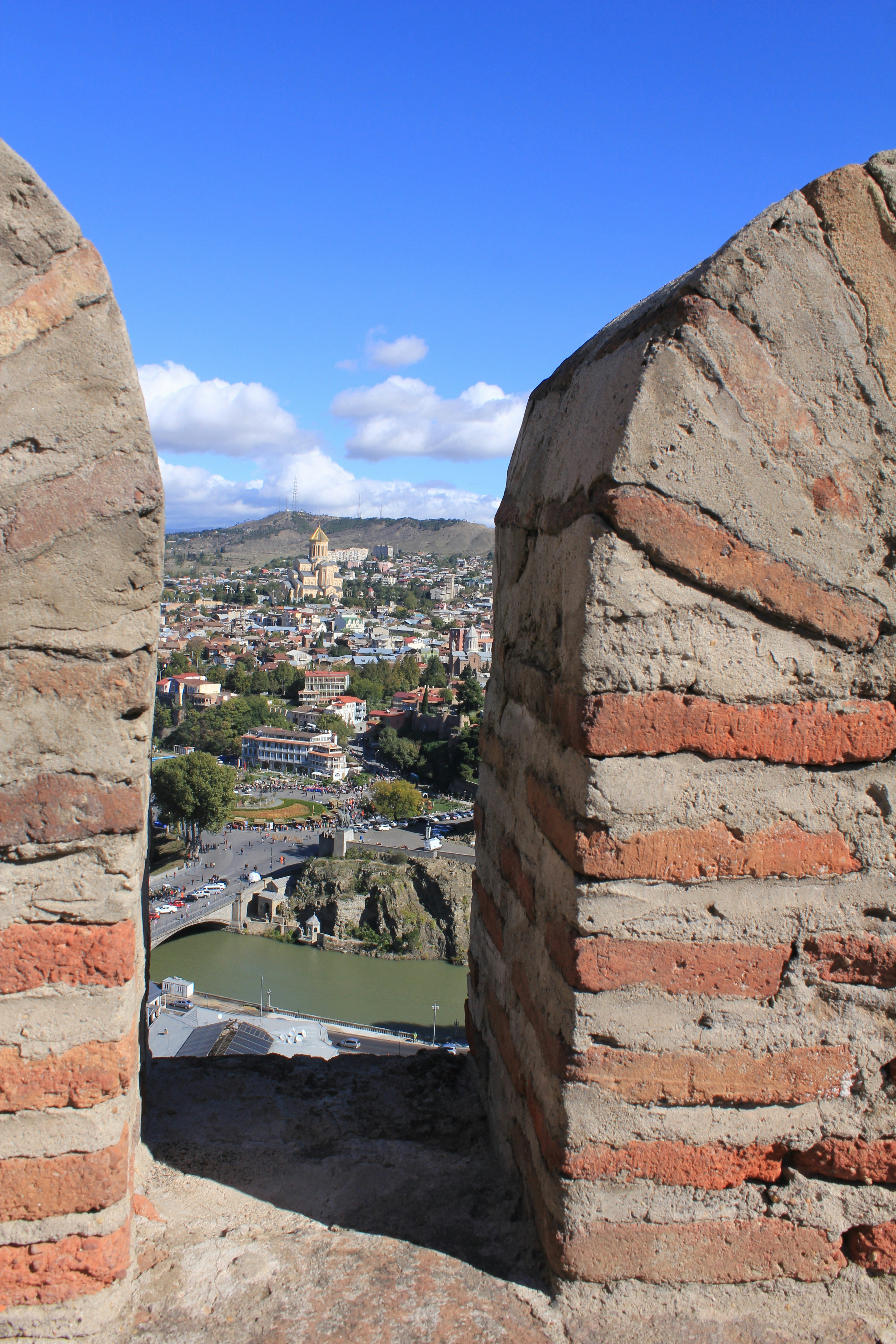 Vista de la ciudad enmarcada por un viejo muro de ladrillo.