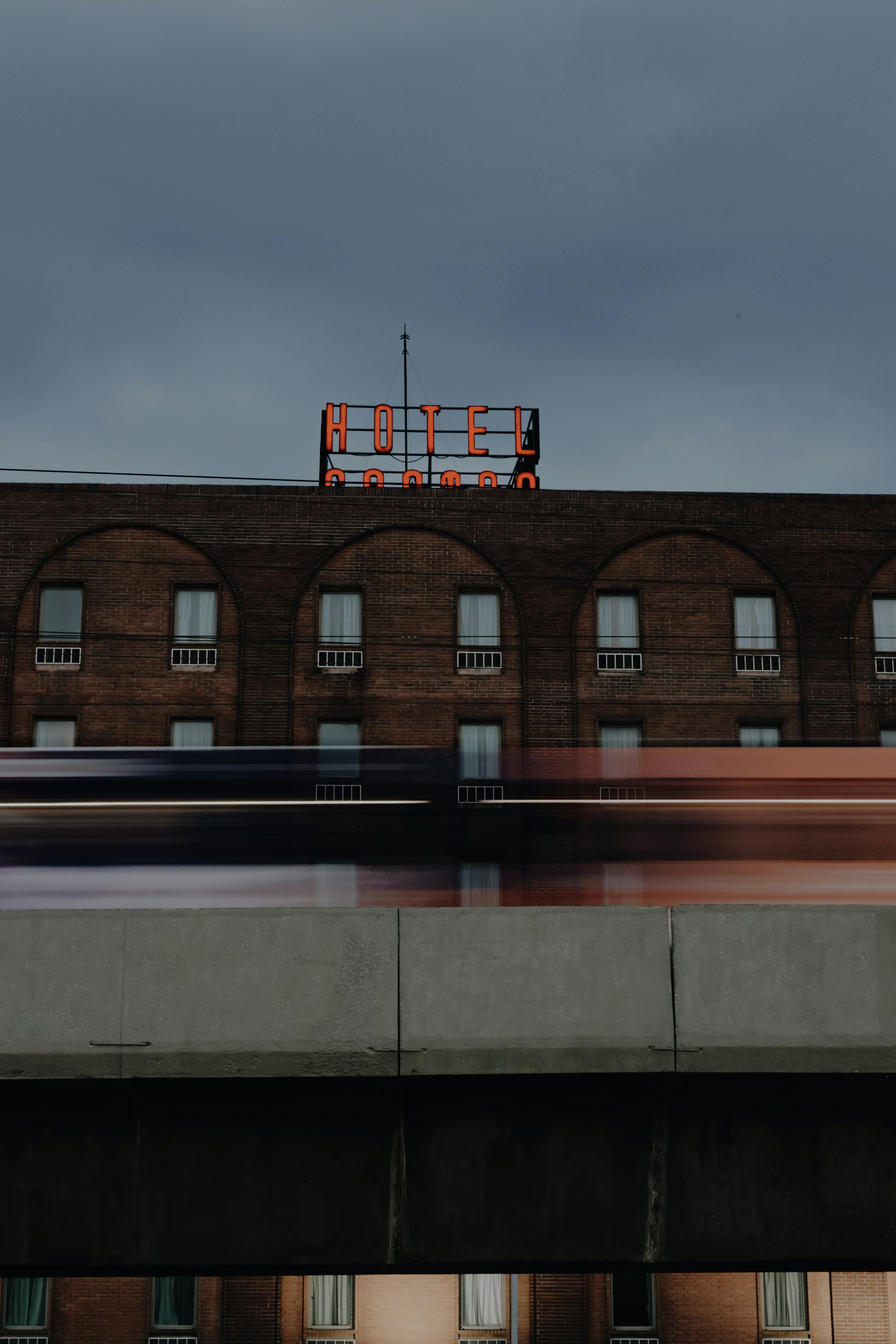 通過するライトのある建物の上にあるホテルの看板。