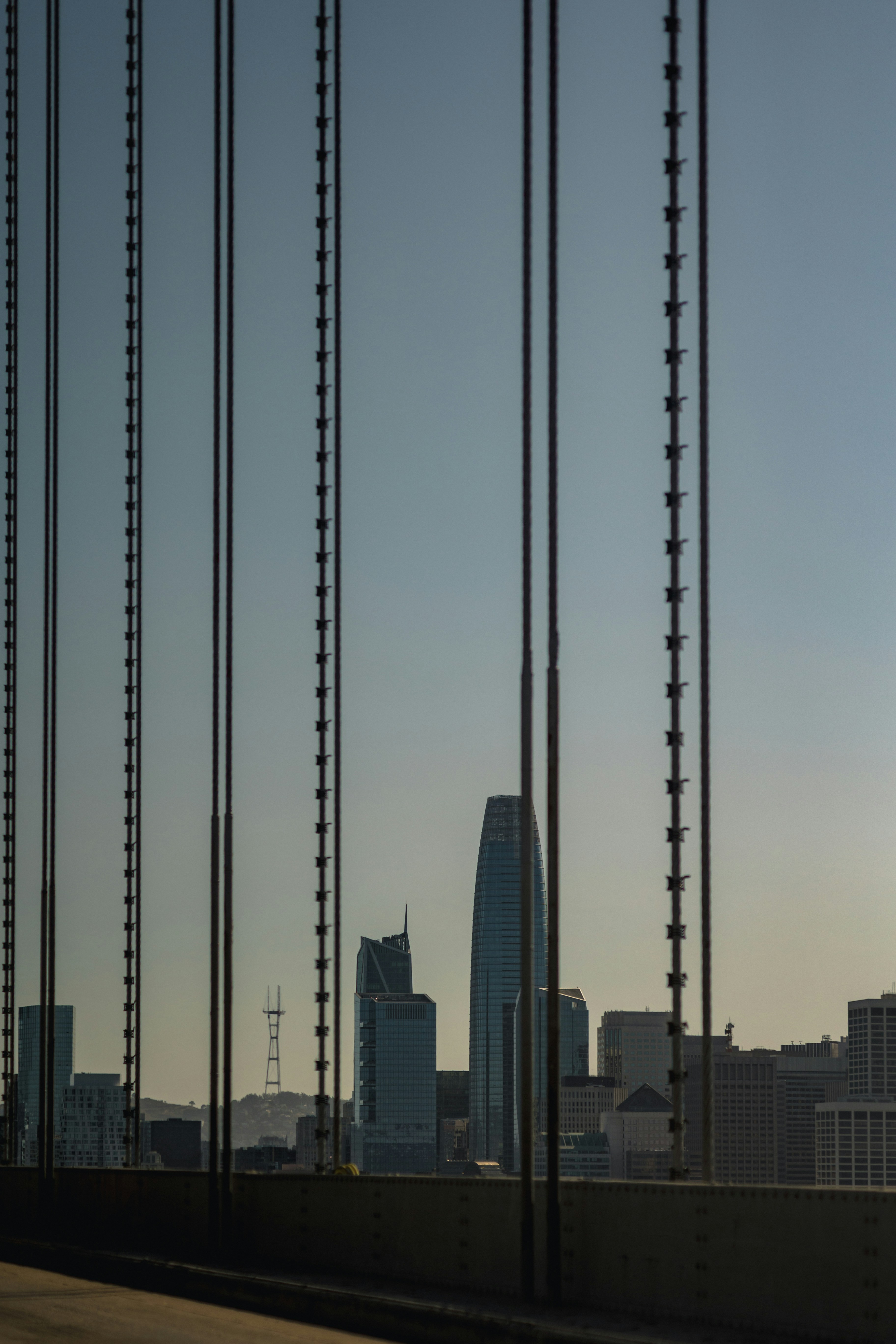 Horizonte de la ciudad visto a través de los cables del puente. foto –  Imagen de Ciudad gratuita en Unsplash, image size:3000x4500