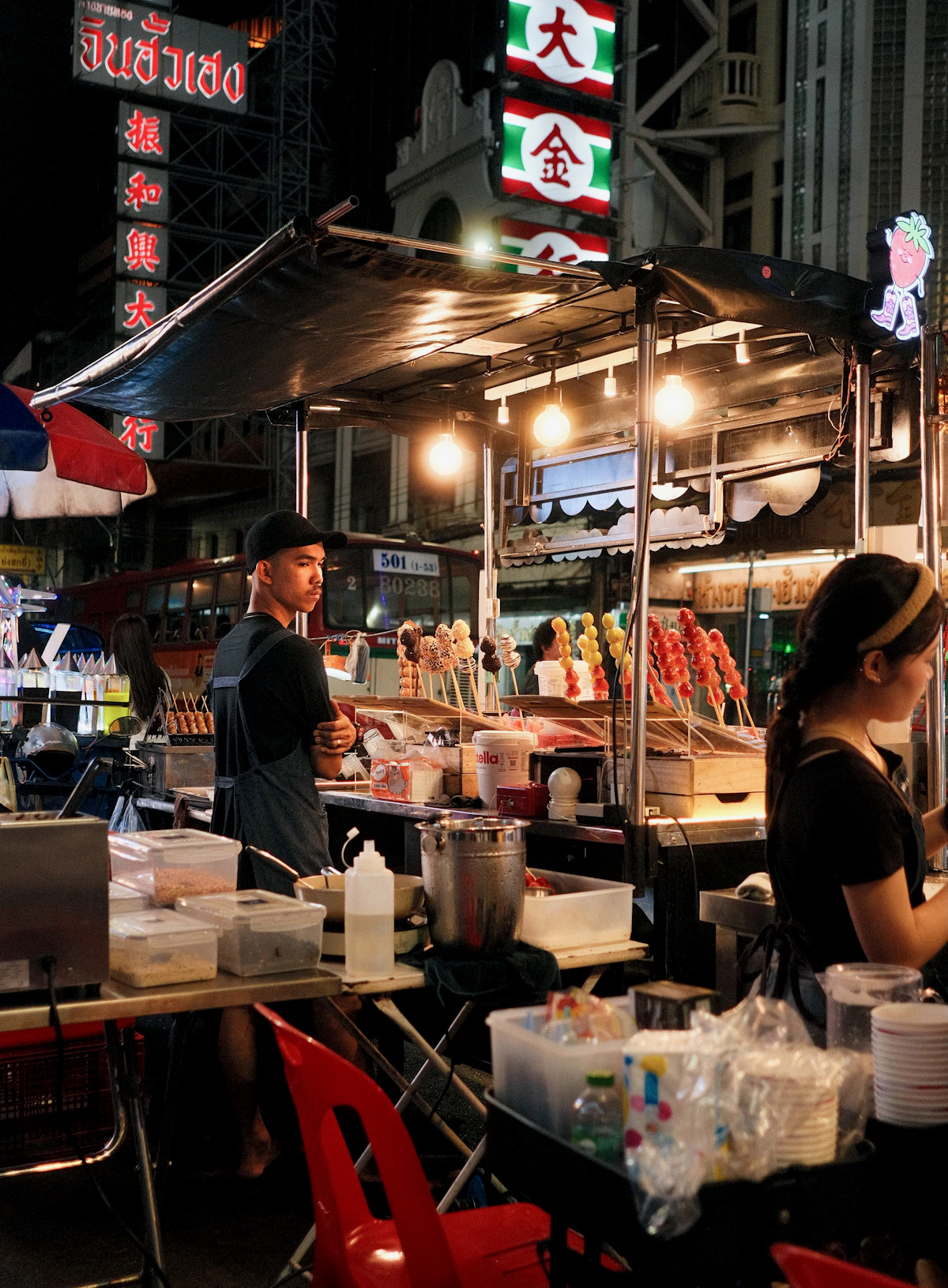 Street-food vendors and illuminated signs on Yaowarat Road in Bangkok at night