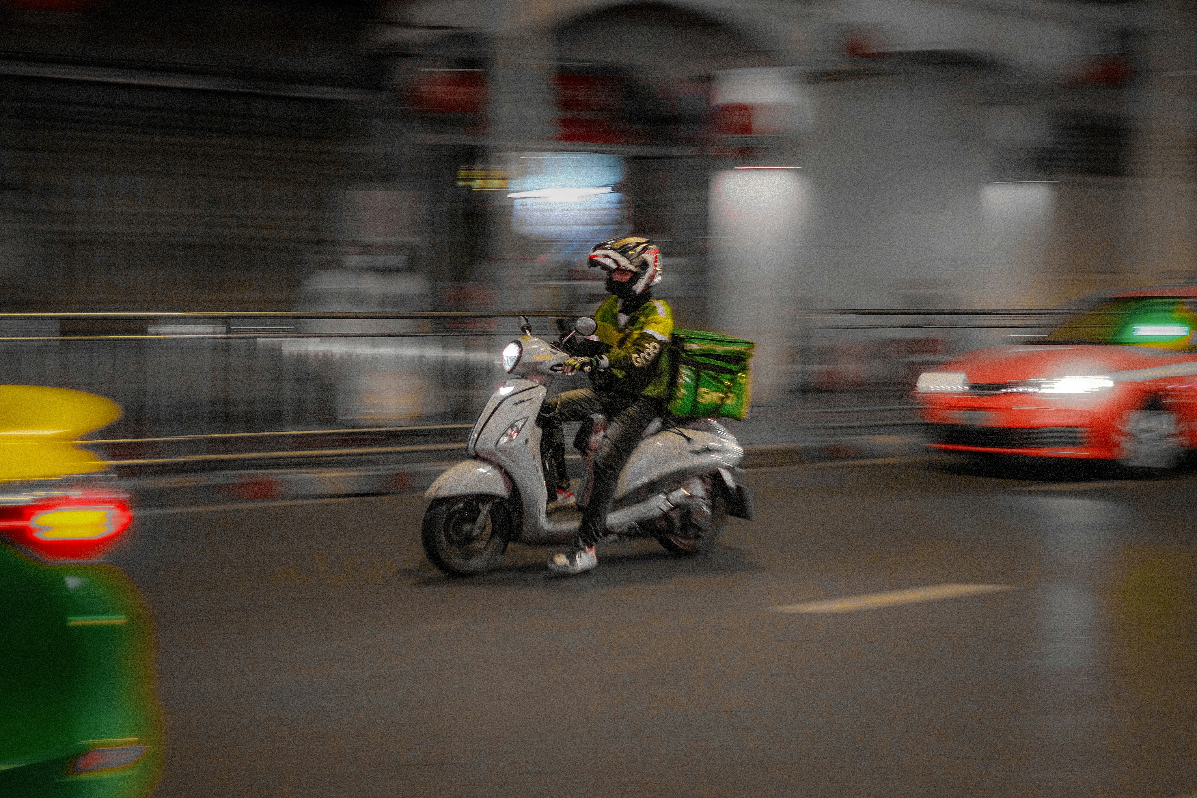 Food delivery driver speeding down a street.