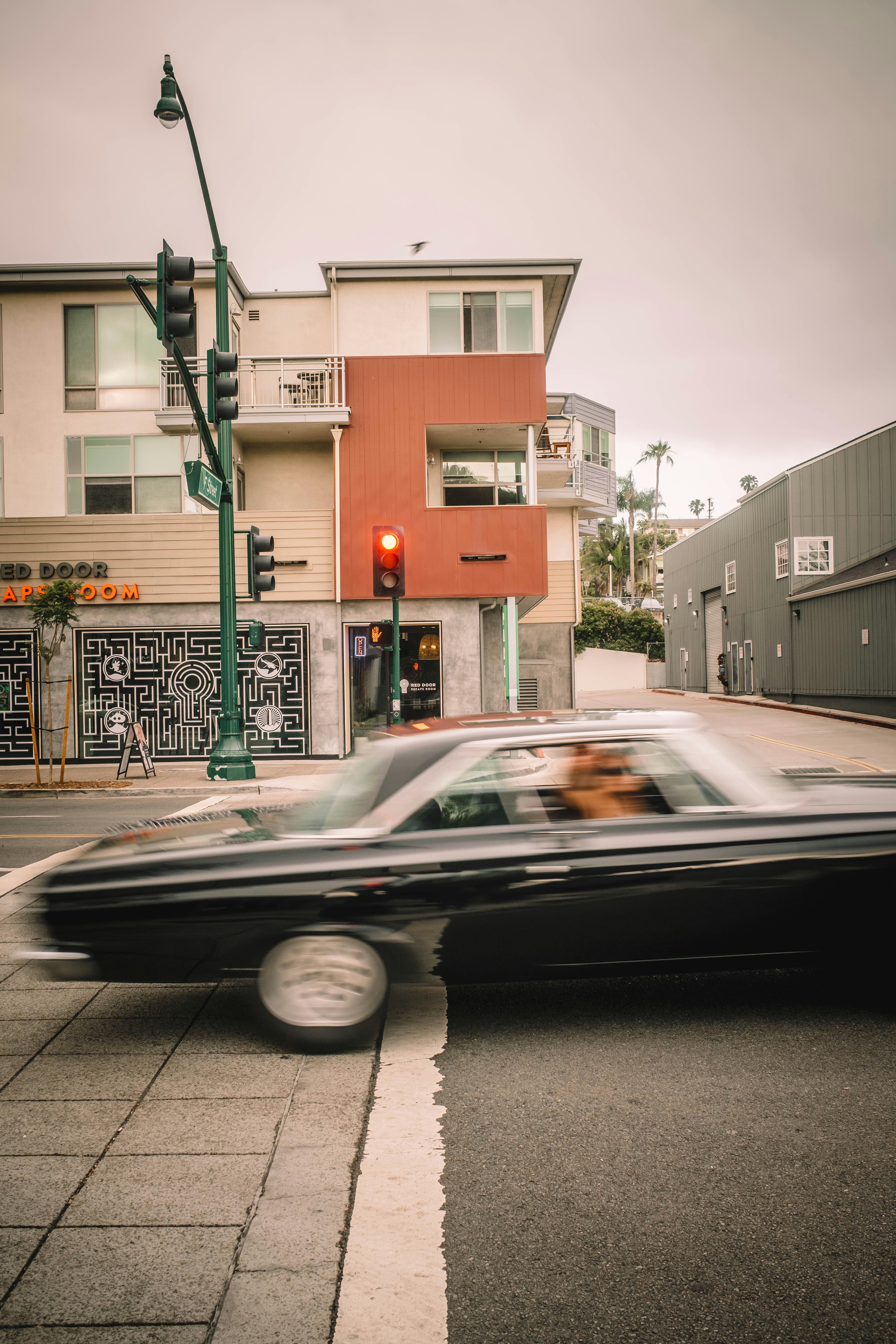 A classic car drives across the street.