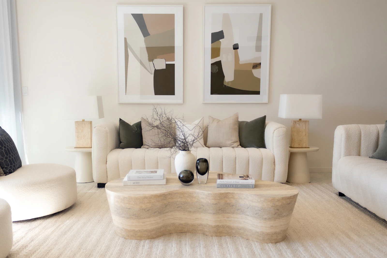 Neutral designer living room with a sculptural table and wall art.