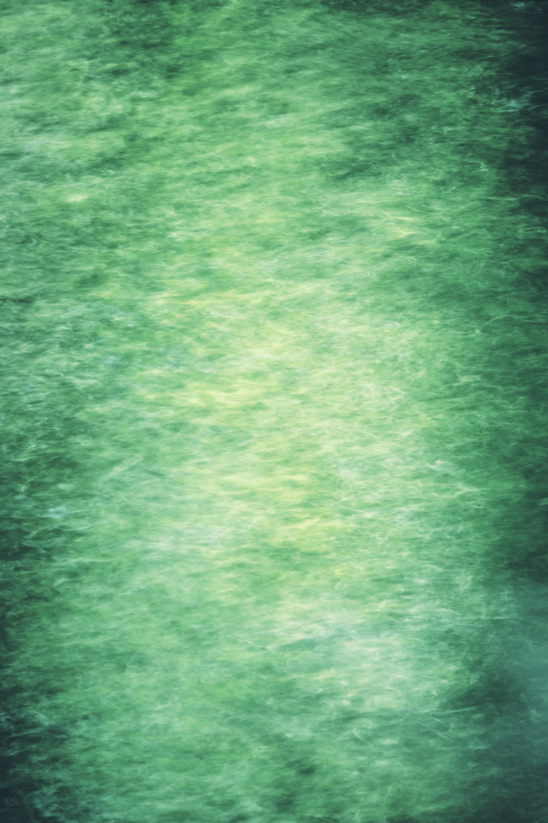 Flowing, emerald green water surface.