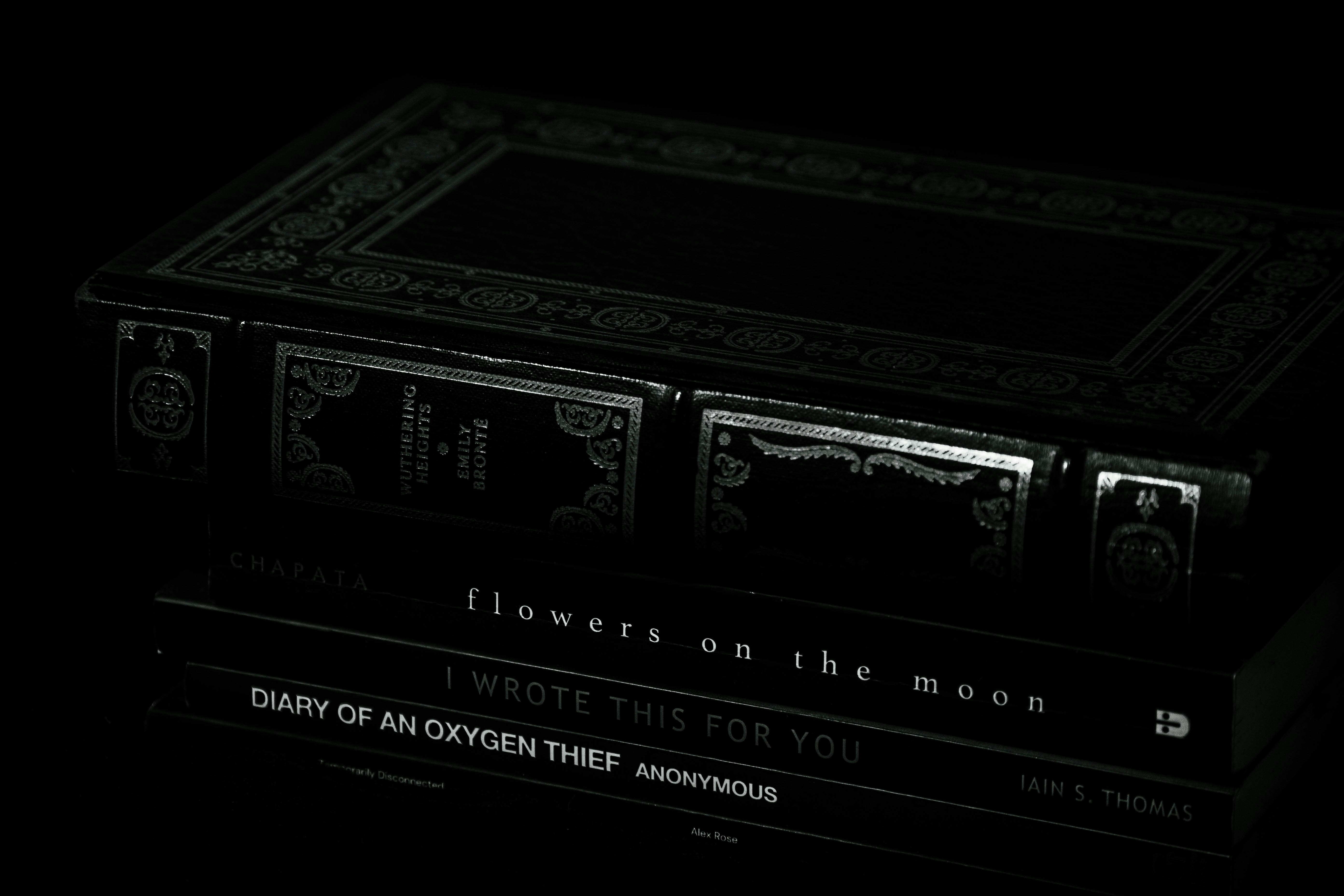 Books are stacked in the dark, dimly lit.