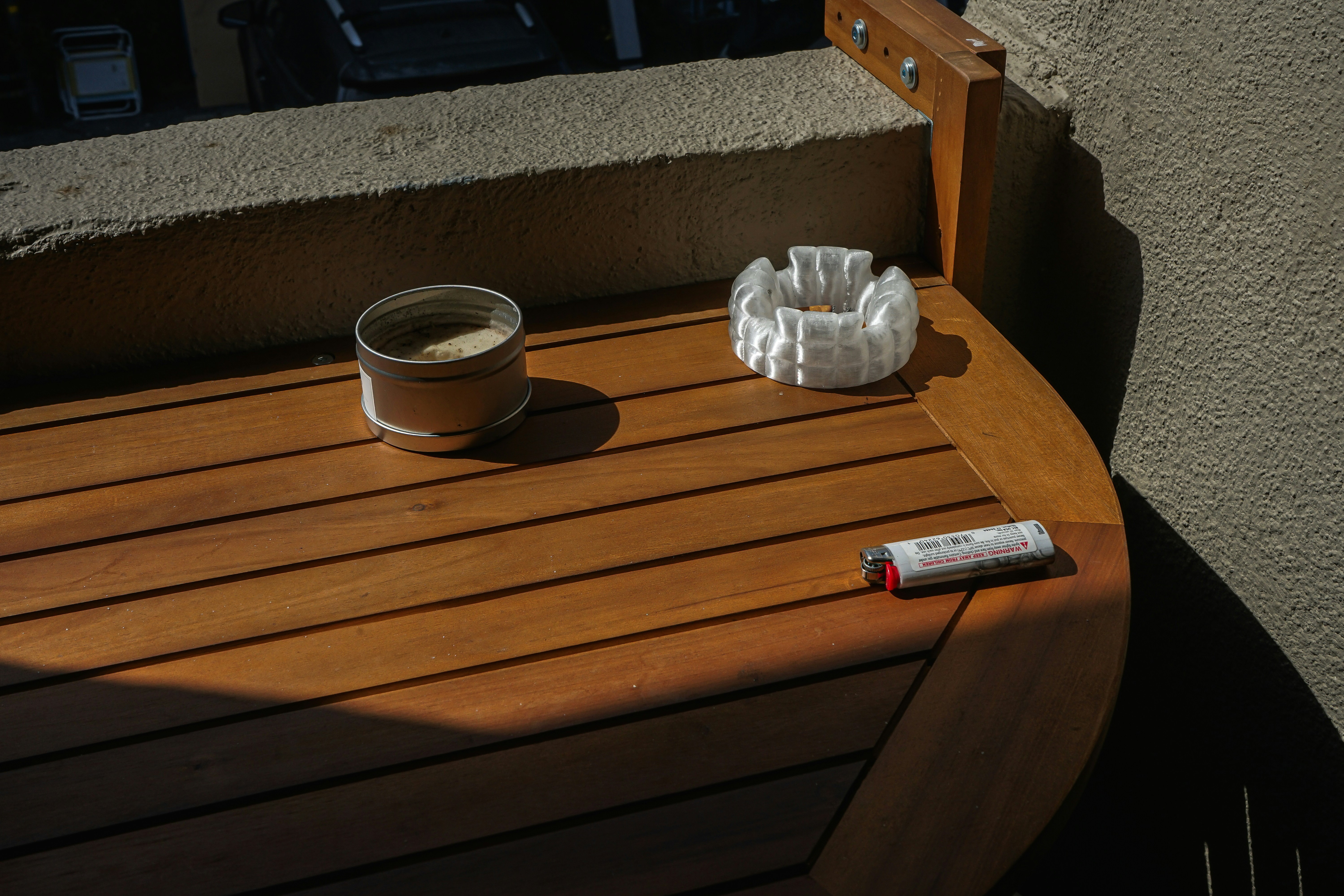 Ashtray, lighter, and tobacco sit on wood.