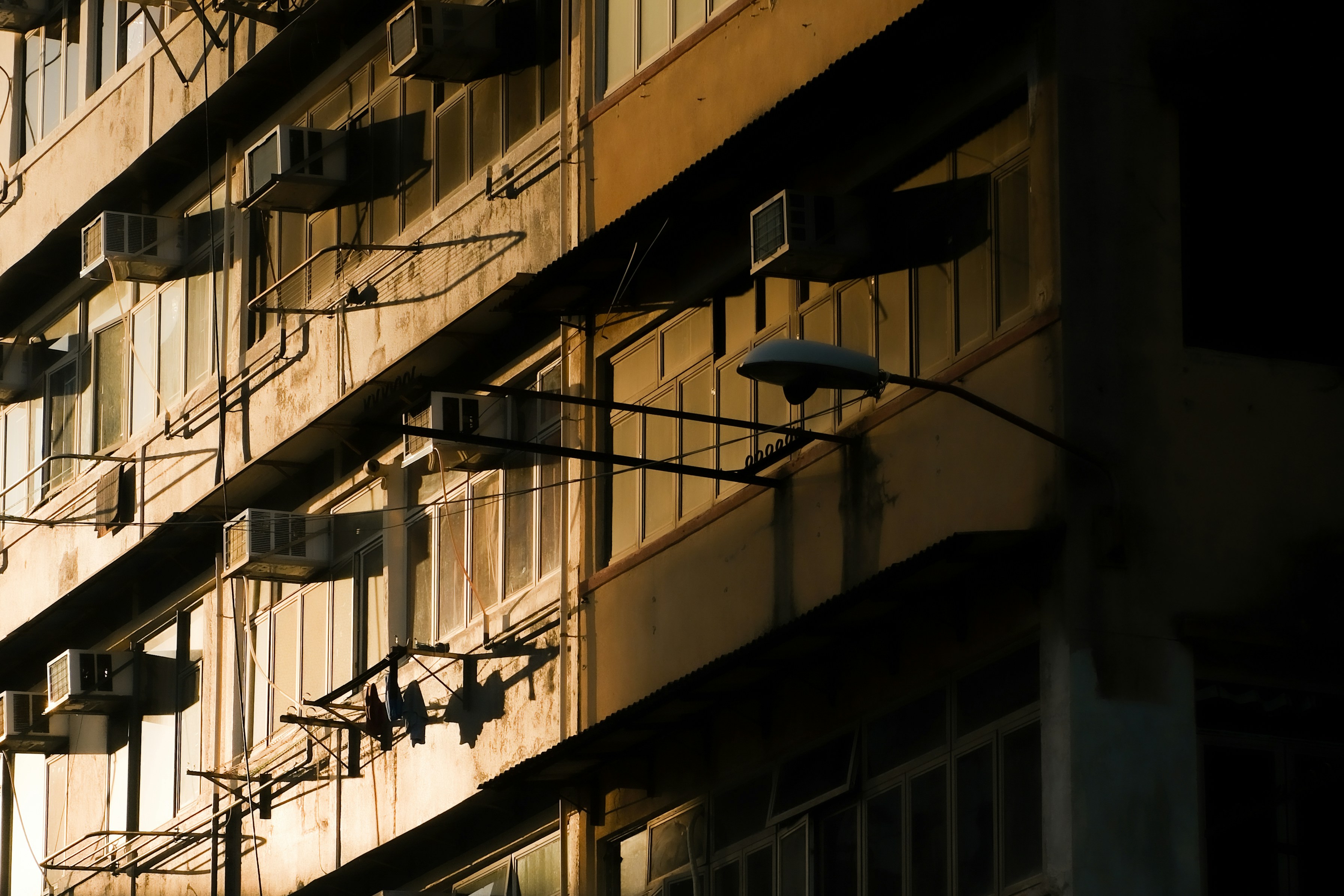 A concrete building with many air conditioners.