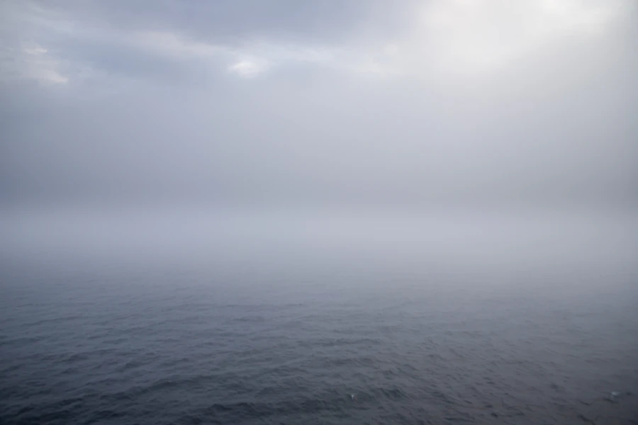Fog rolling over a calm, open sea
