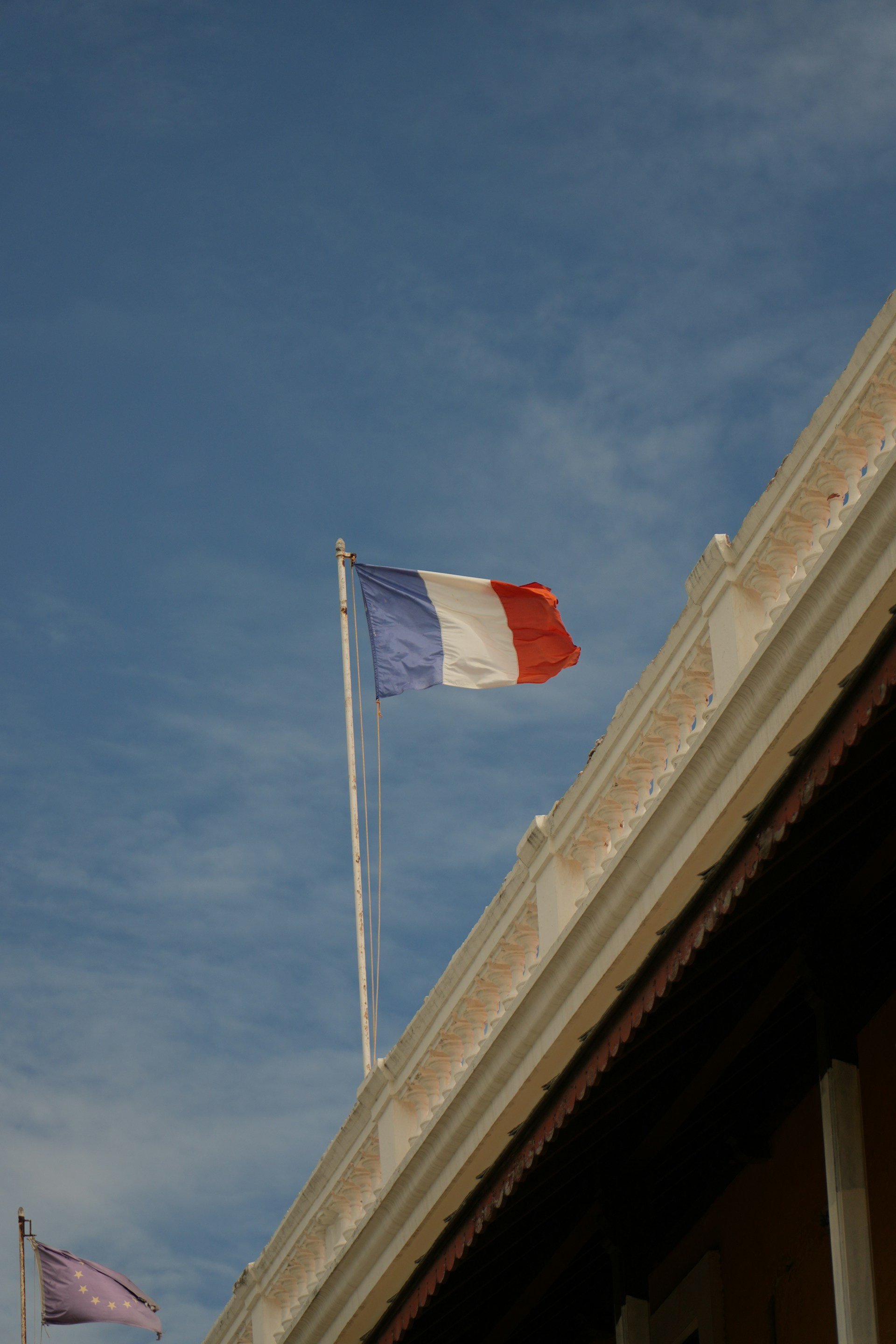 The french flag waves proudly in the sky.