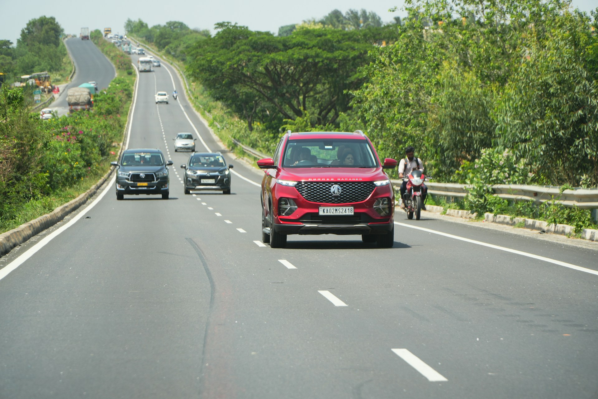 Cars are driving on a long, open highway.