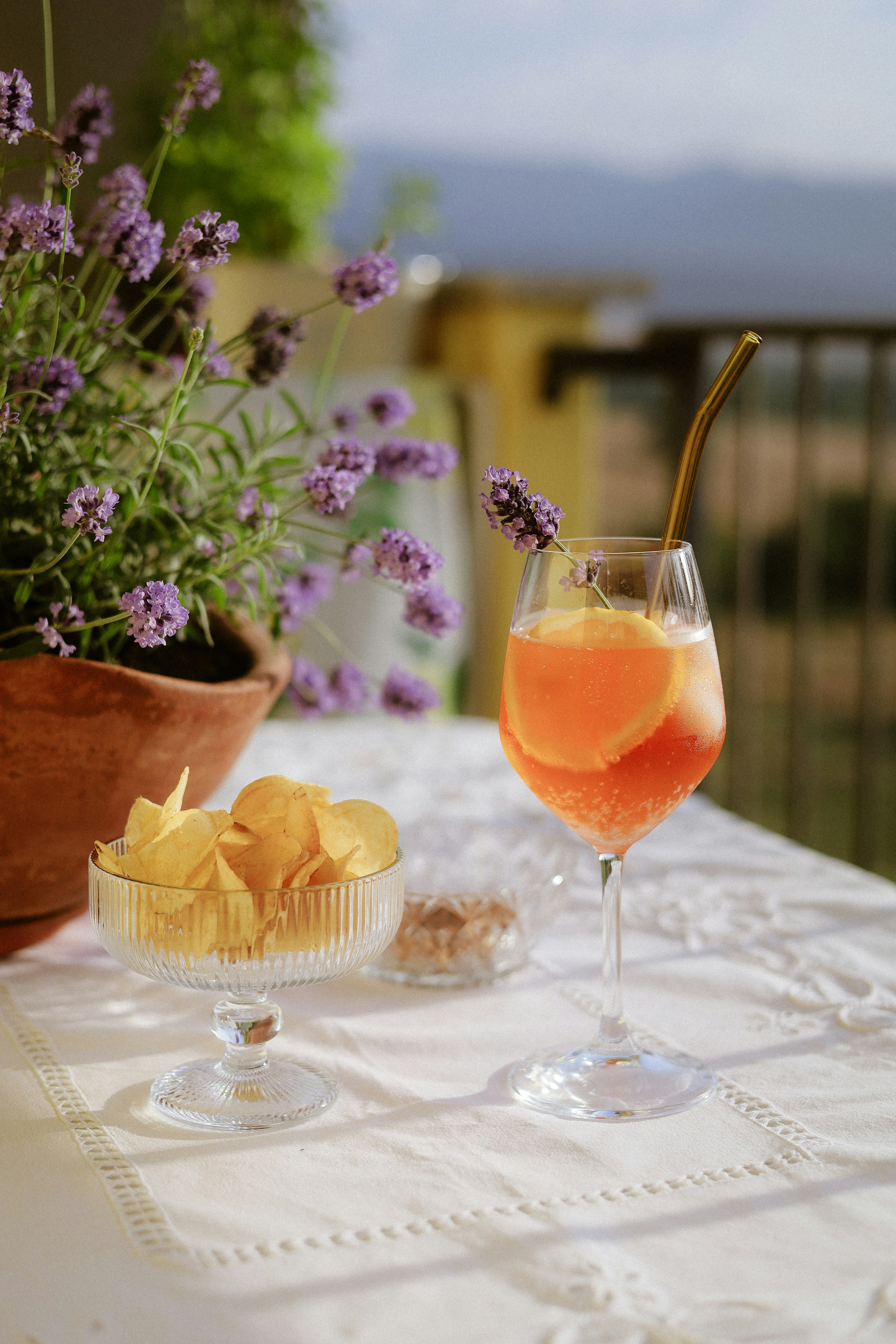 Aperol spritz with chips and lavender on a table.
