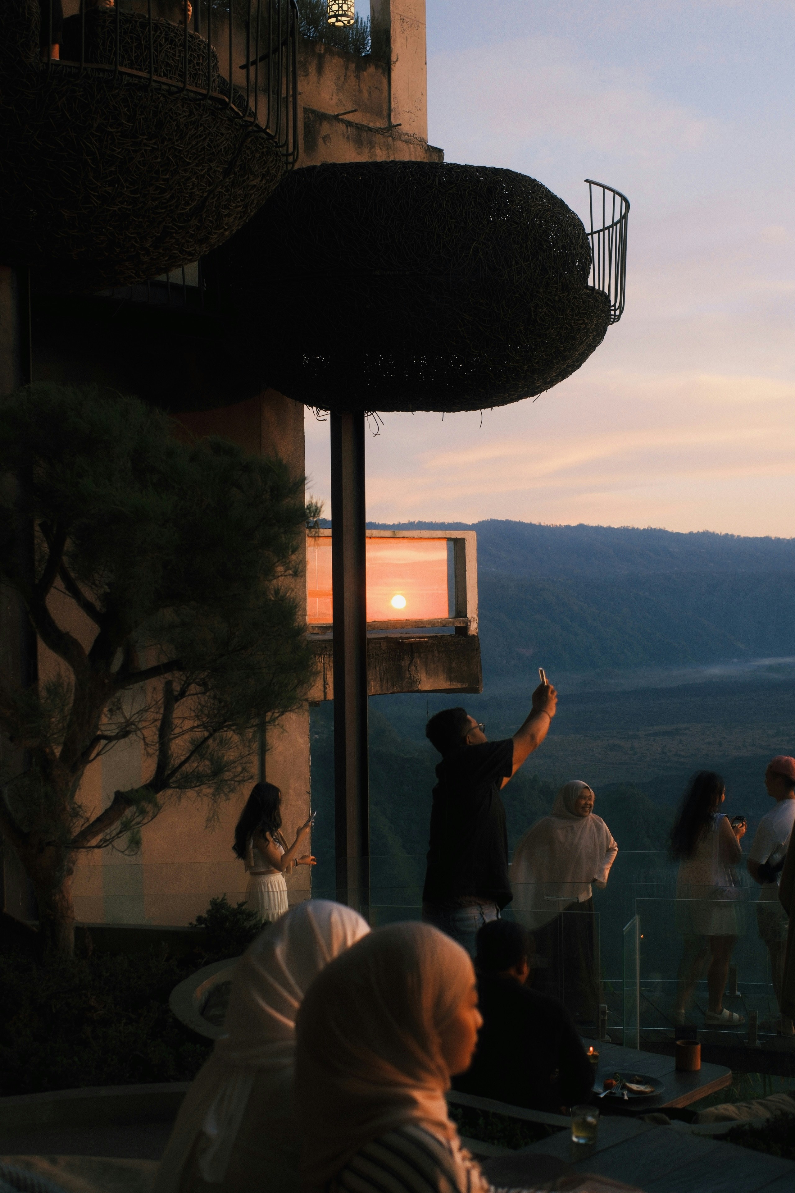 People watch the sunset on a scenic balcony.