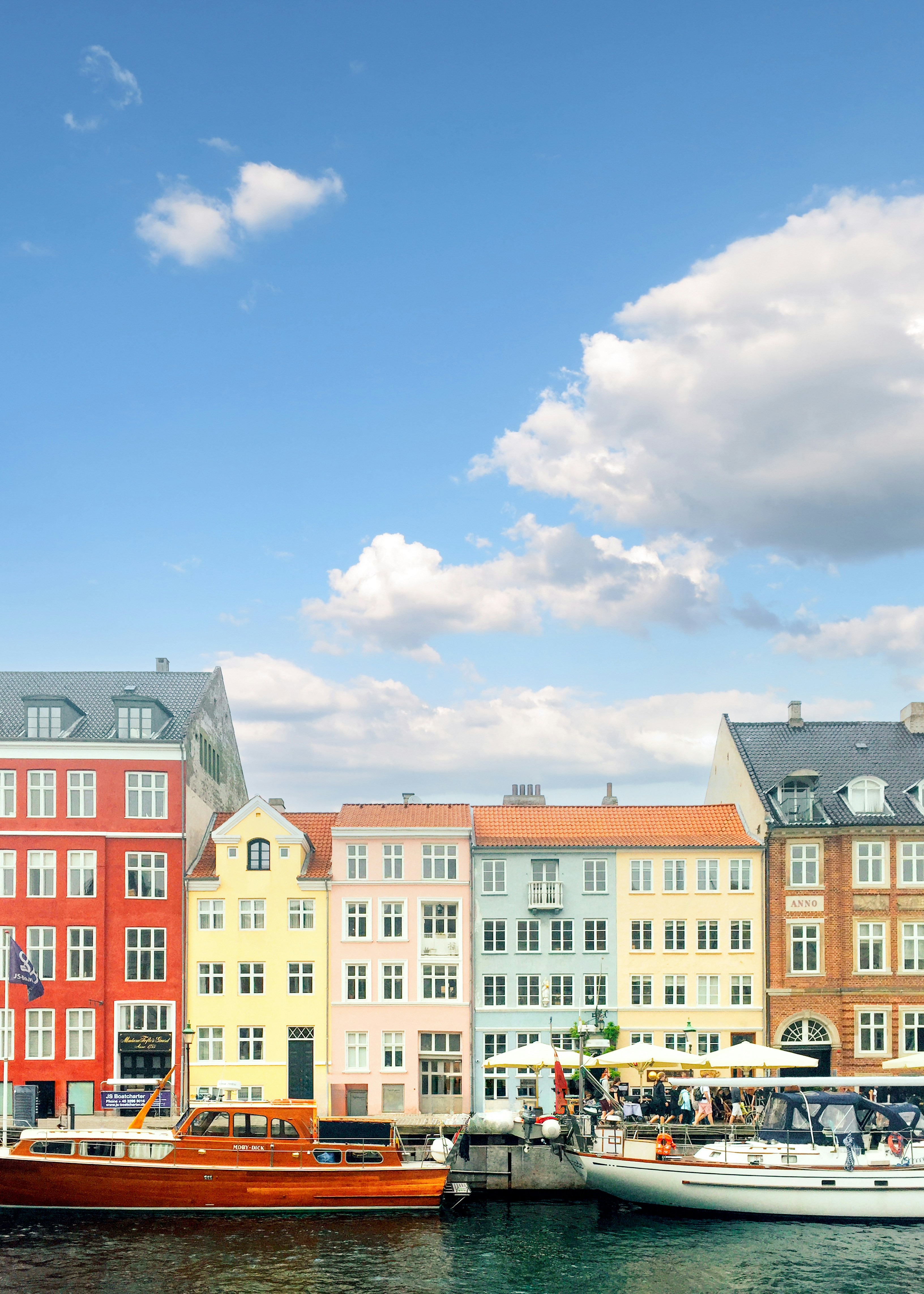 Colorful buildings line a canal on a sunny day.