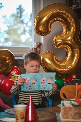 A young boy reads a birthday card.