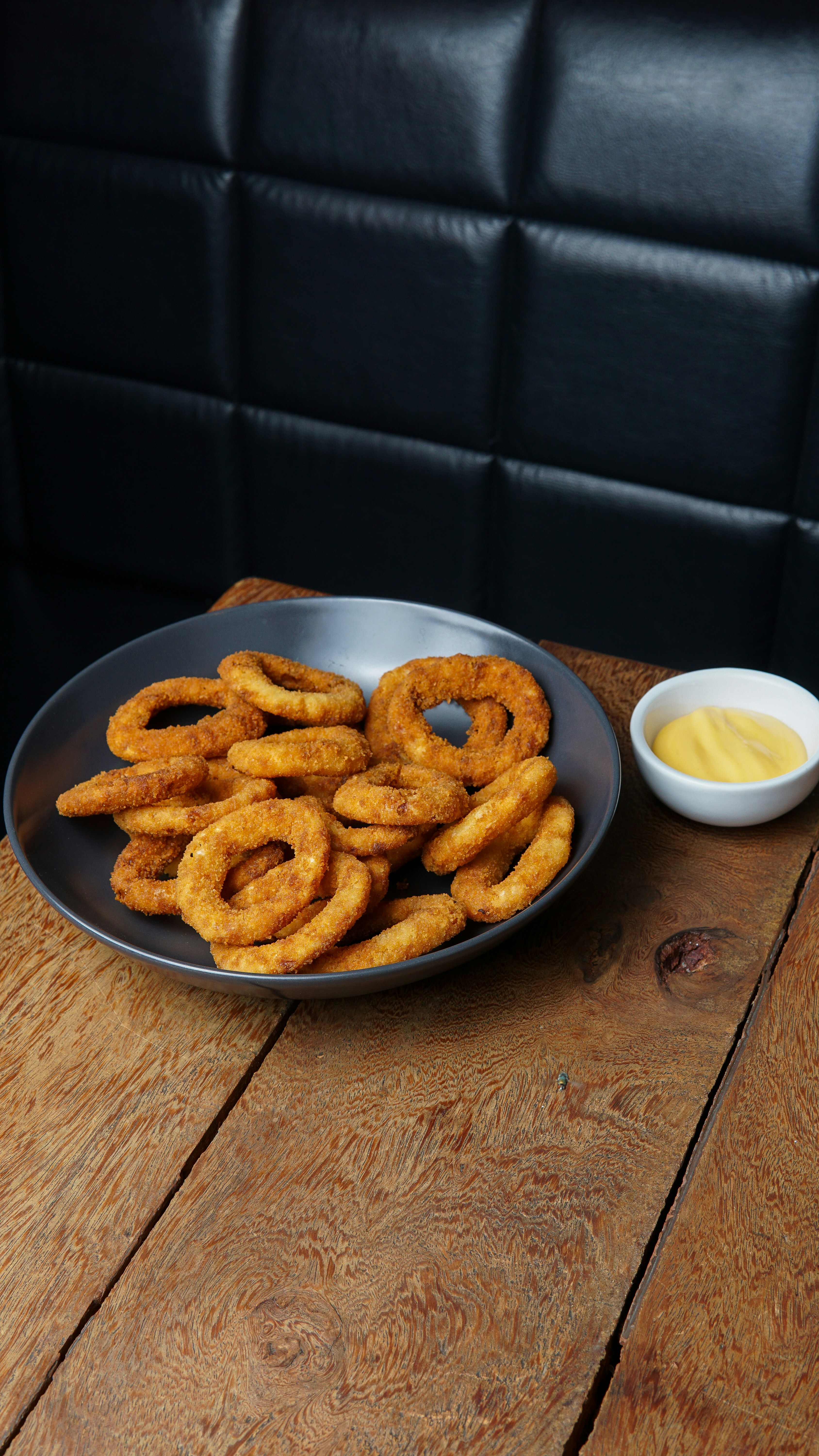 Onion rings and dip on a wooden table