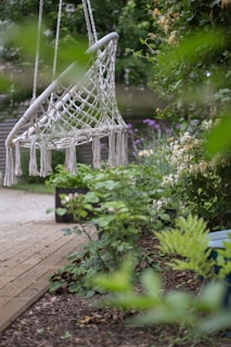 A relaxing macrame swing in a lush garden.