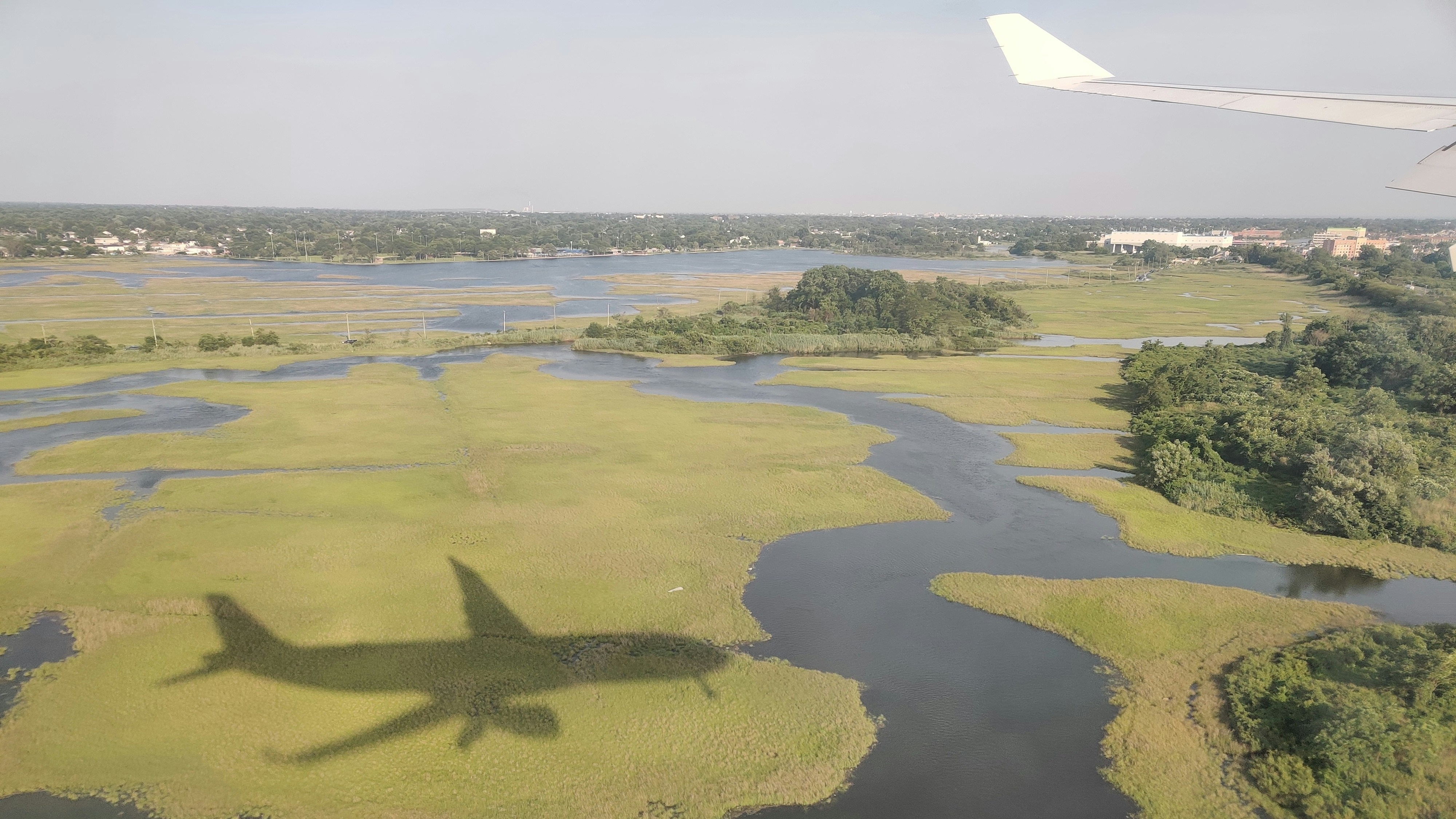An airplane's shadow falls on a landscape.