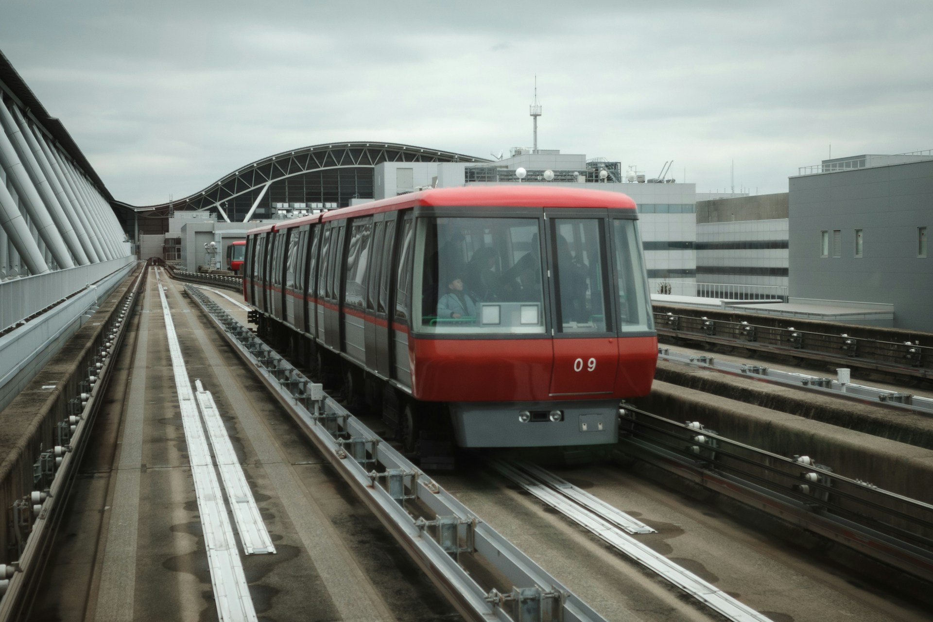 A red train is traveling on the tracks.