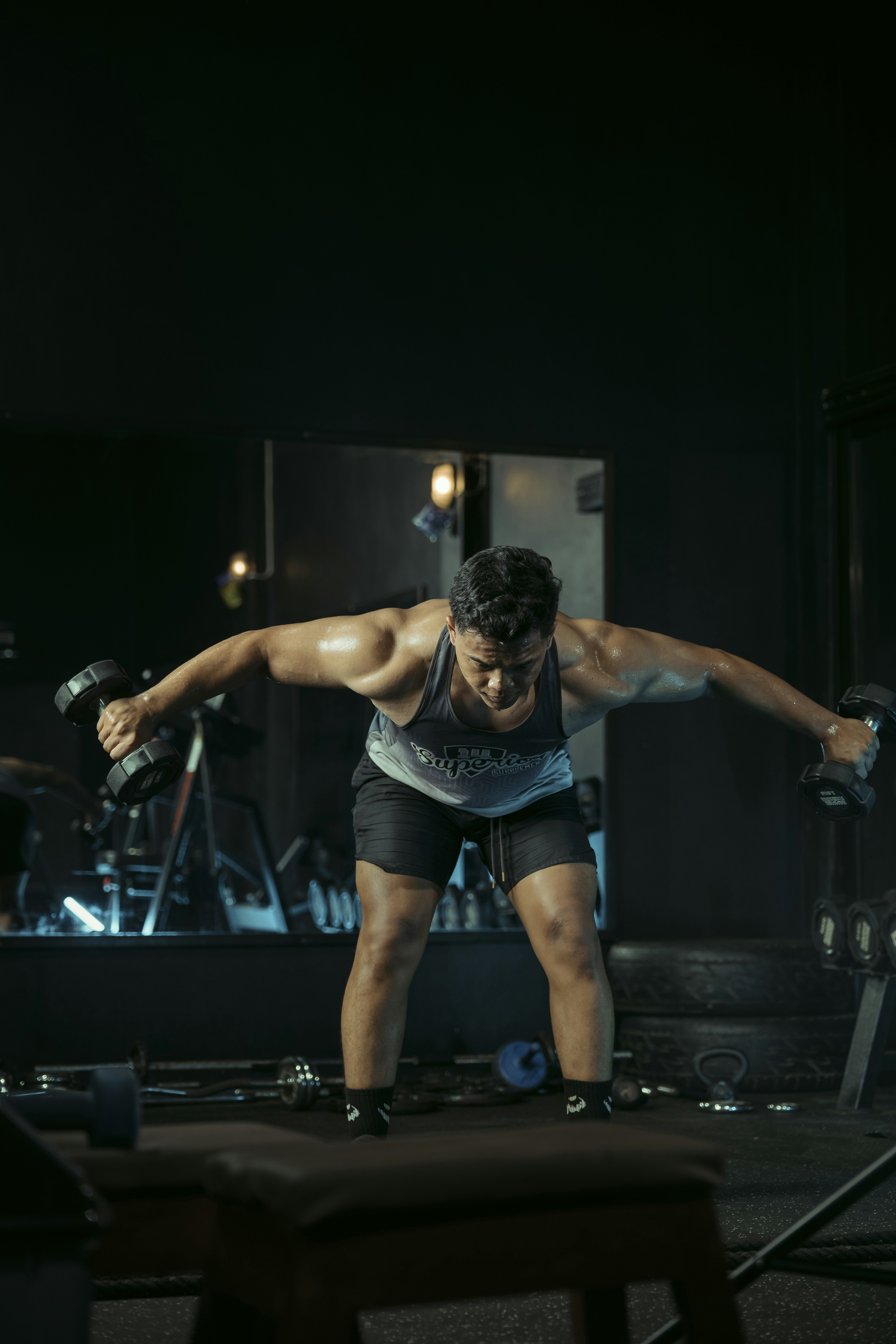 Man works out with dumbbells in a gym.