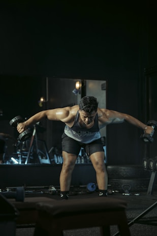 Man works out with dumbbells in a gym.