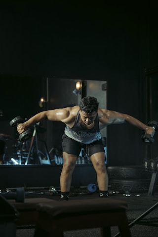 Man works out with dumbbells in a gym.