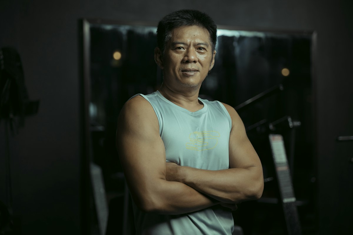 Fit man standing in the gym with arms crossed