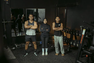 Three people pose at the gym.