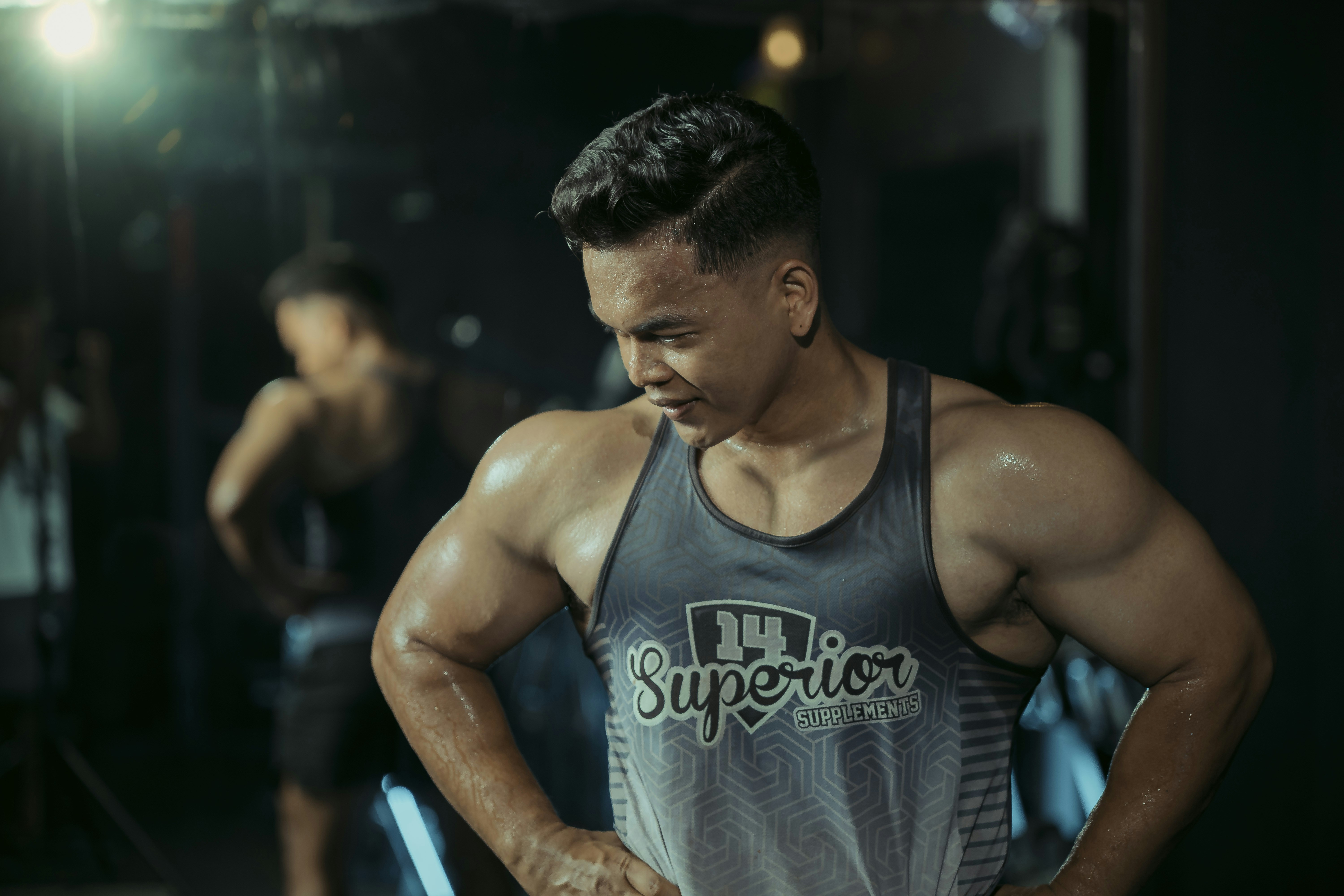 A muscular man is flexing in the gym.